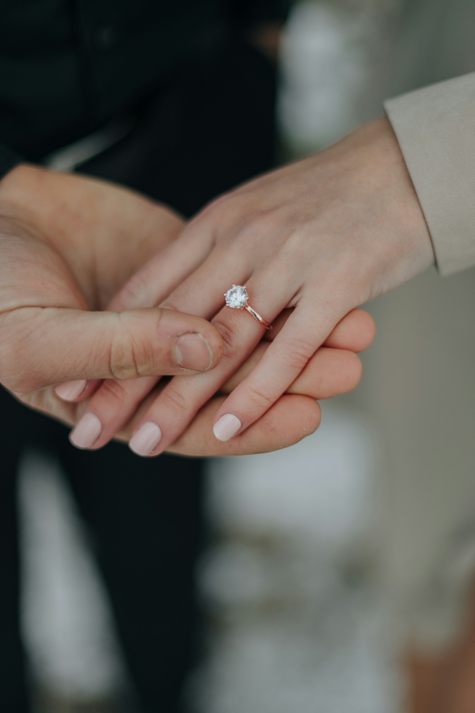 Nahaufnahme einer Frau, die ihren Diamantring zur Schau stellt, während sie die Hand ihres Partners hält | Quelle: Unsplash