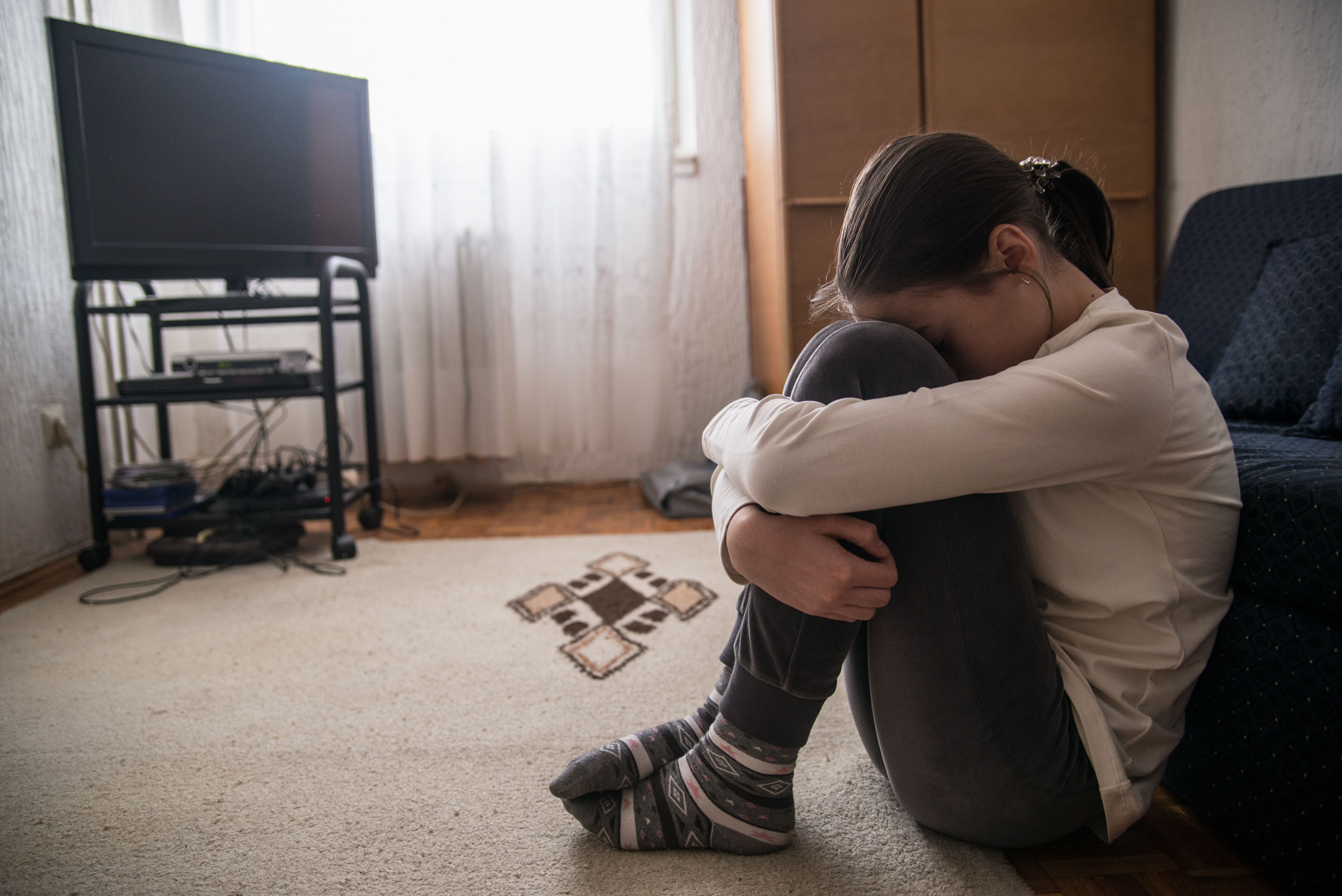 Teenagerin mit Kopfschmerzen, die sich den Kopf hält | Quelle: Getty Images