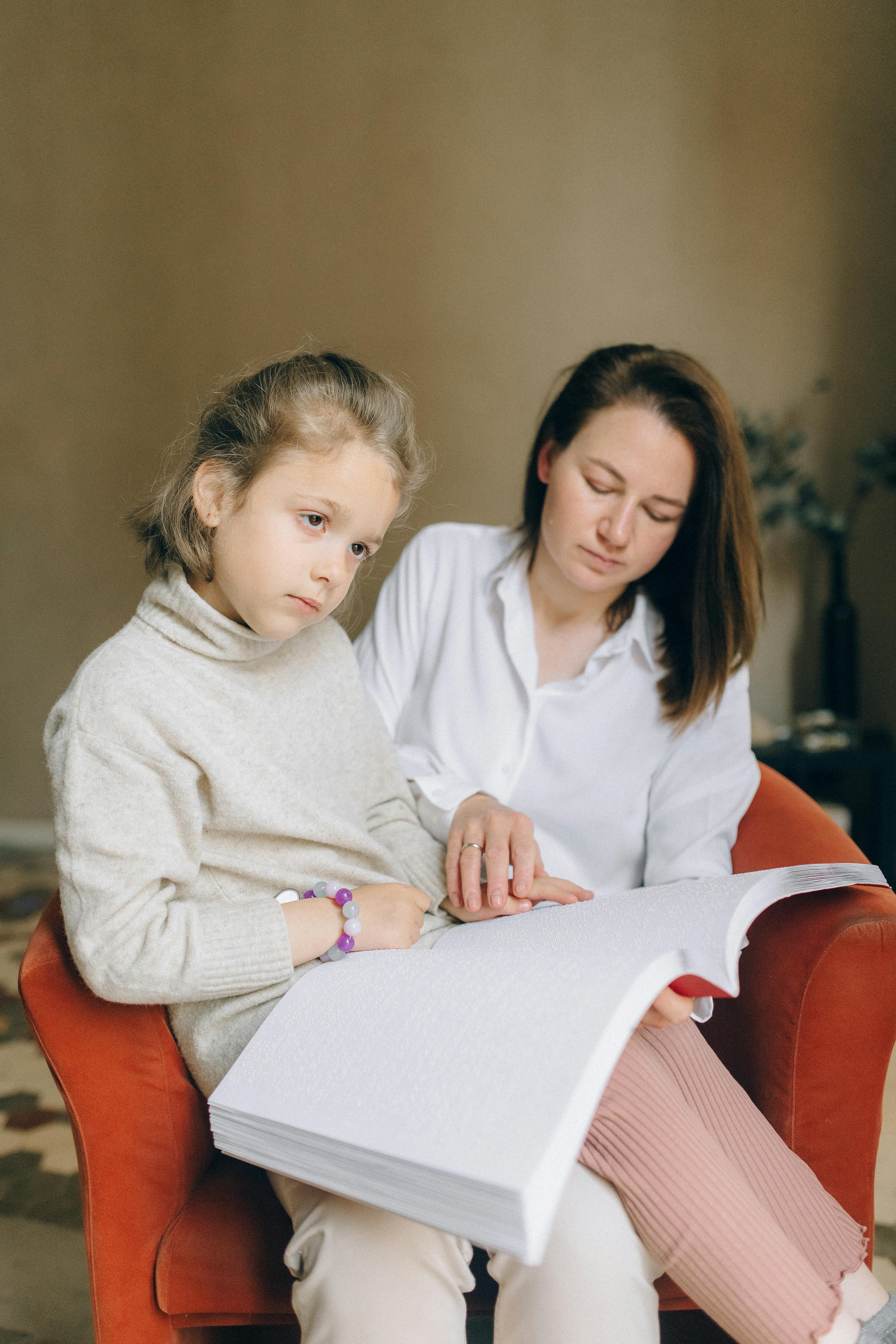 Eine Frau hilft ihrem Kind zu lesen | Quelle: Pexels