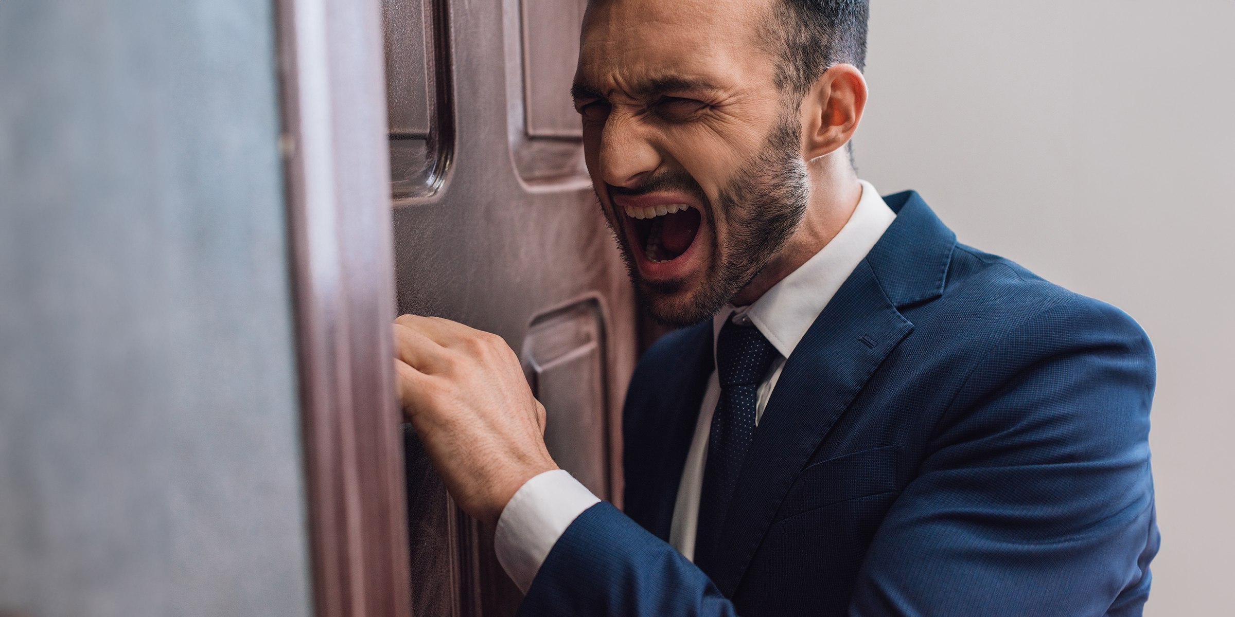 Ein wütender Mann klopft an eine Tür | Quelle: Shutterstock