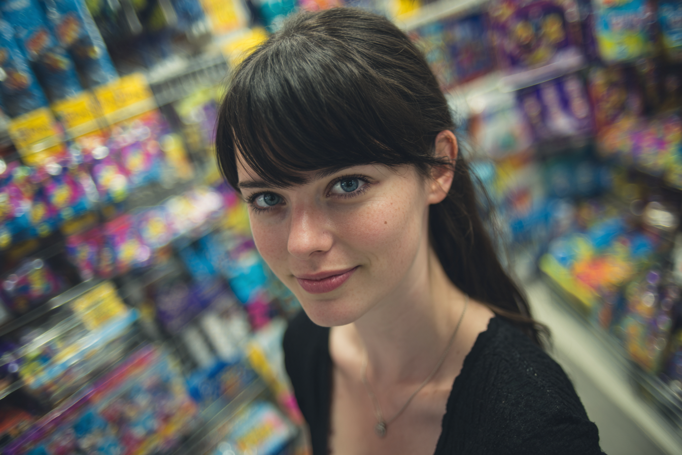 Eine Frau lächelt verschmitzt, während sie in einem Dollar Store einkauft | Quelle: Midjourney