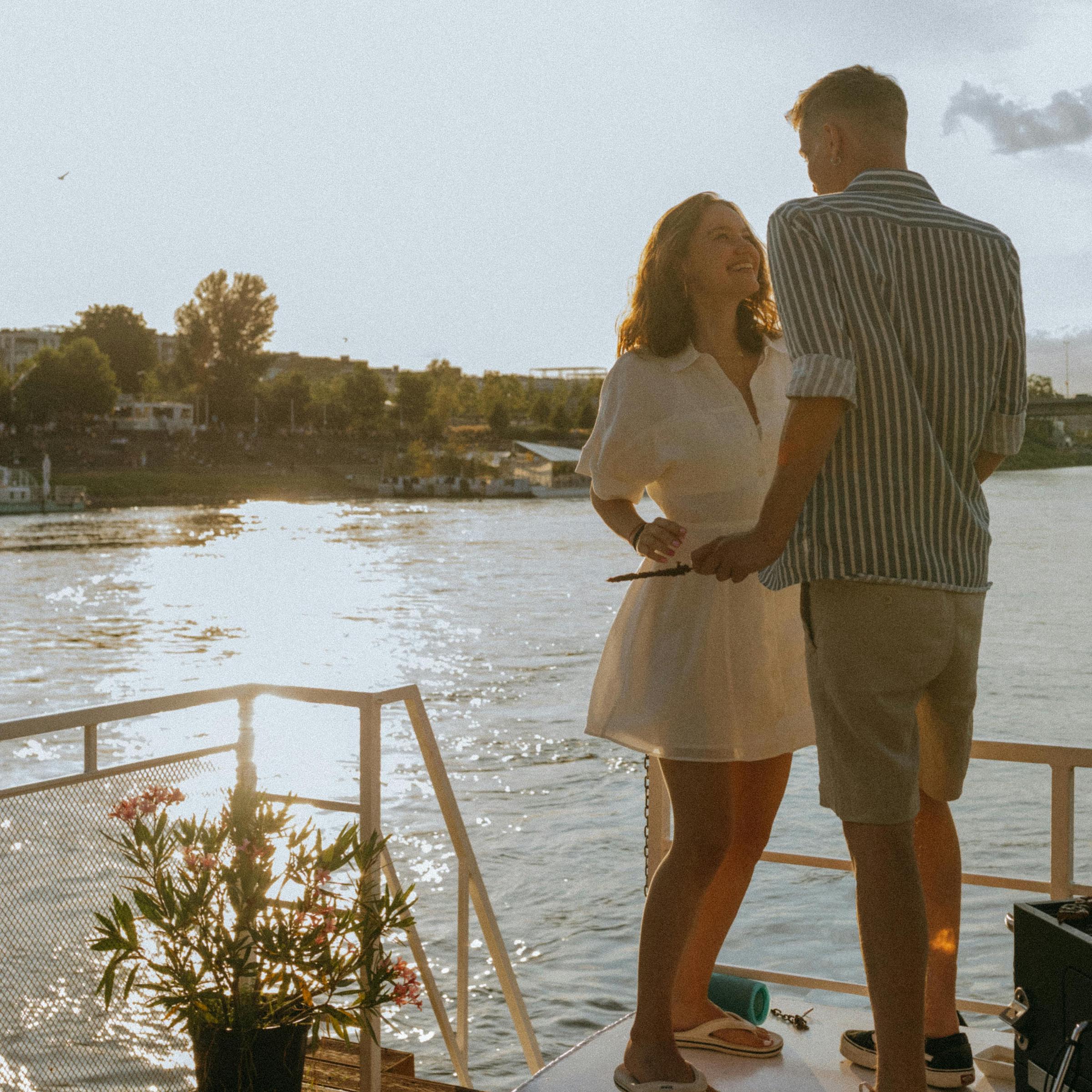 Eine lächelnde Frau, die sich mit einem Mann auf dem Deck eines Bootes unterhält | Quelle: Pexels