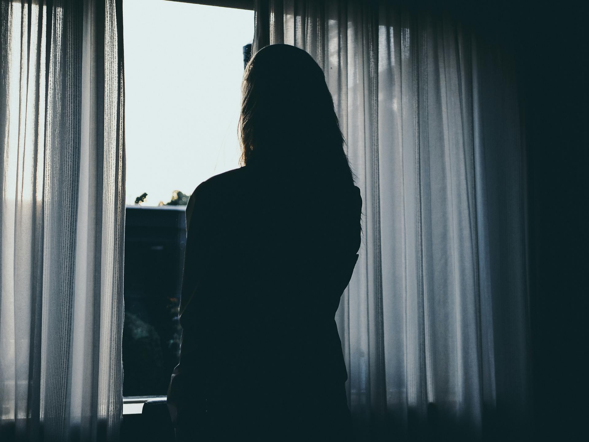 Eine Frau, die am Fenster steht | Quelle: Pexels