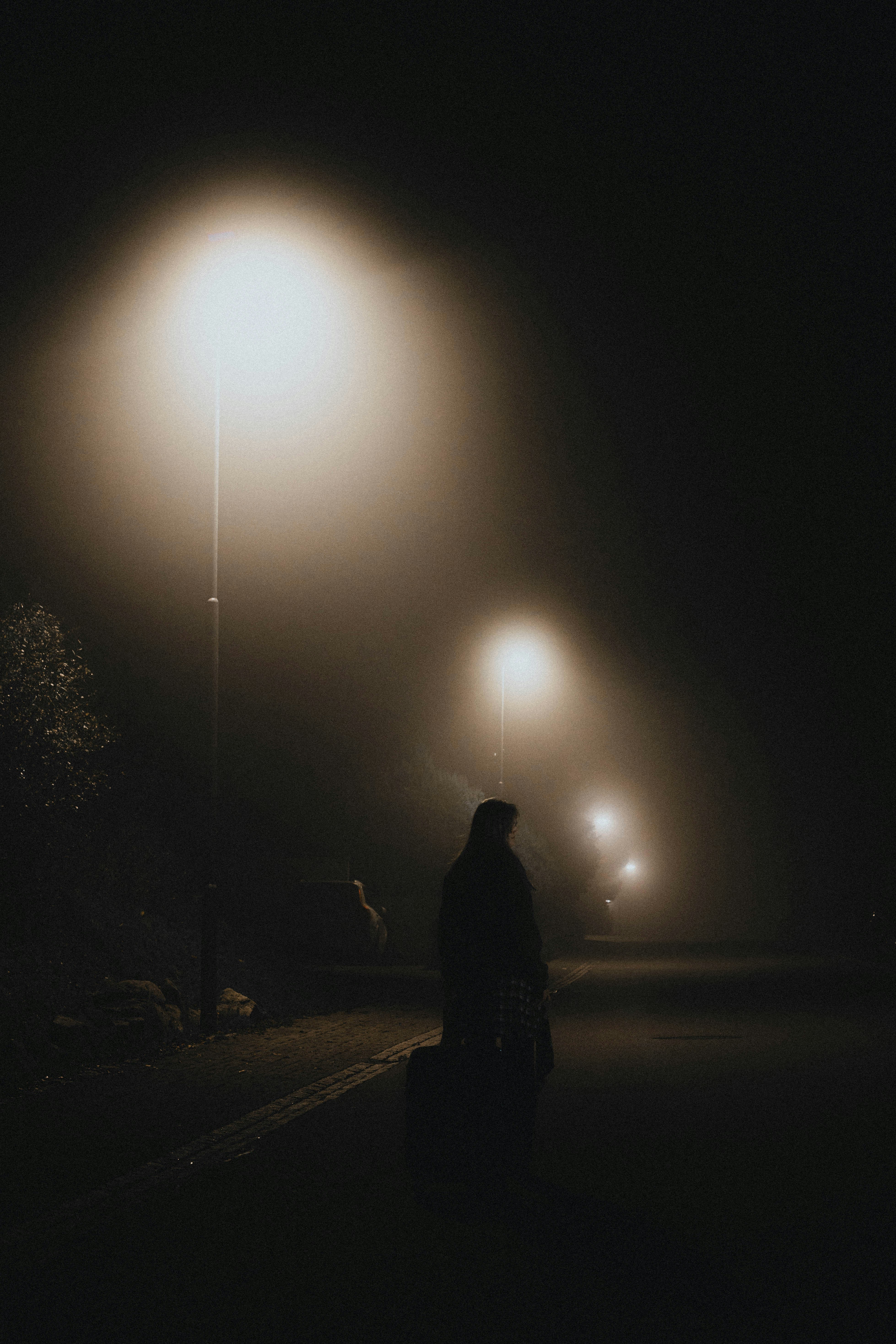 Eine Frau steht nachts auf einer Straße | Quelle: Unsplash