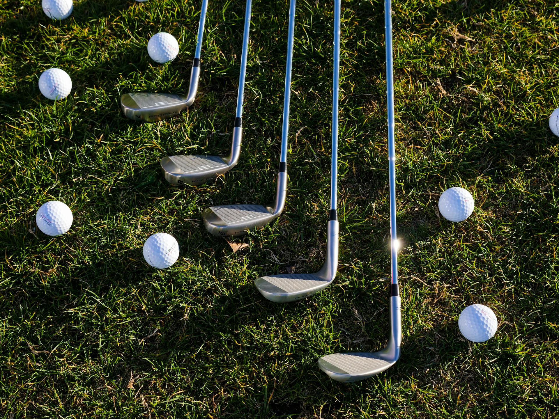 Golfbälle und Golfschläger liegen auf dem Rasen | Quelle: Pexels