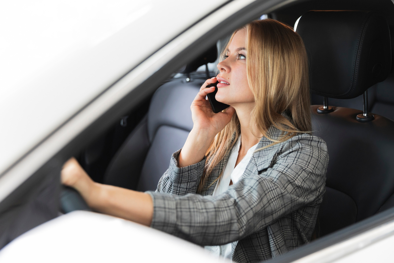 Eine Frau, die in ihrem Auto sitzt und telefoniert | Quelle: Freepik