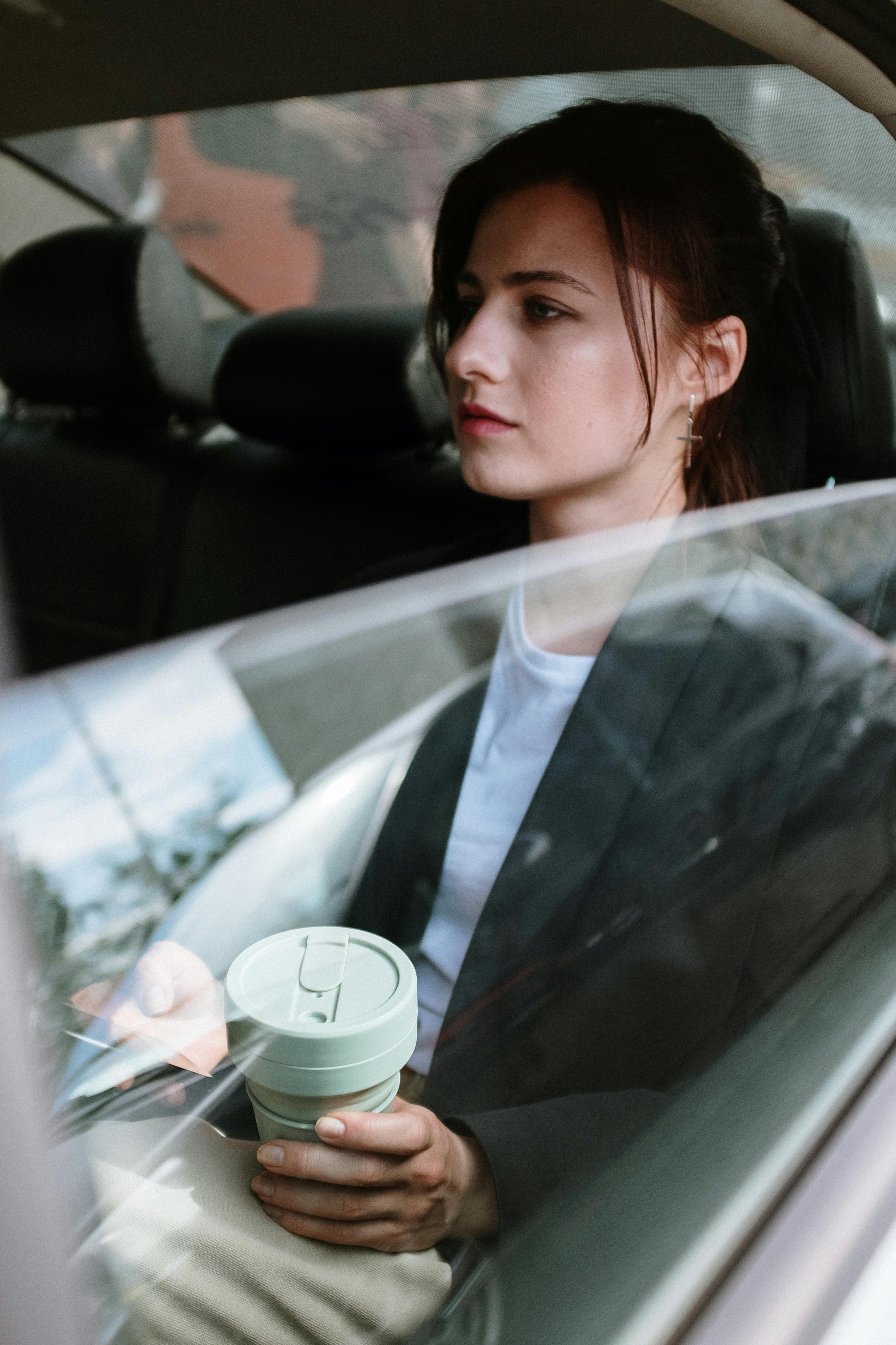 Eine ernste Frau auf dem Rücksitz eines Autos | Quelle: Pexels
