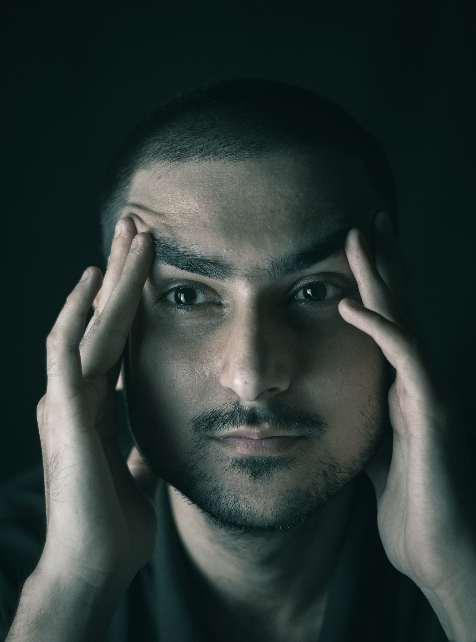 Ein angespannter Mann, der sich die Schläfen reibt | Quelle: Unsplash