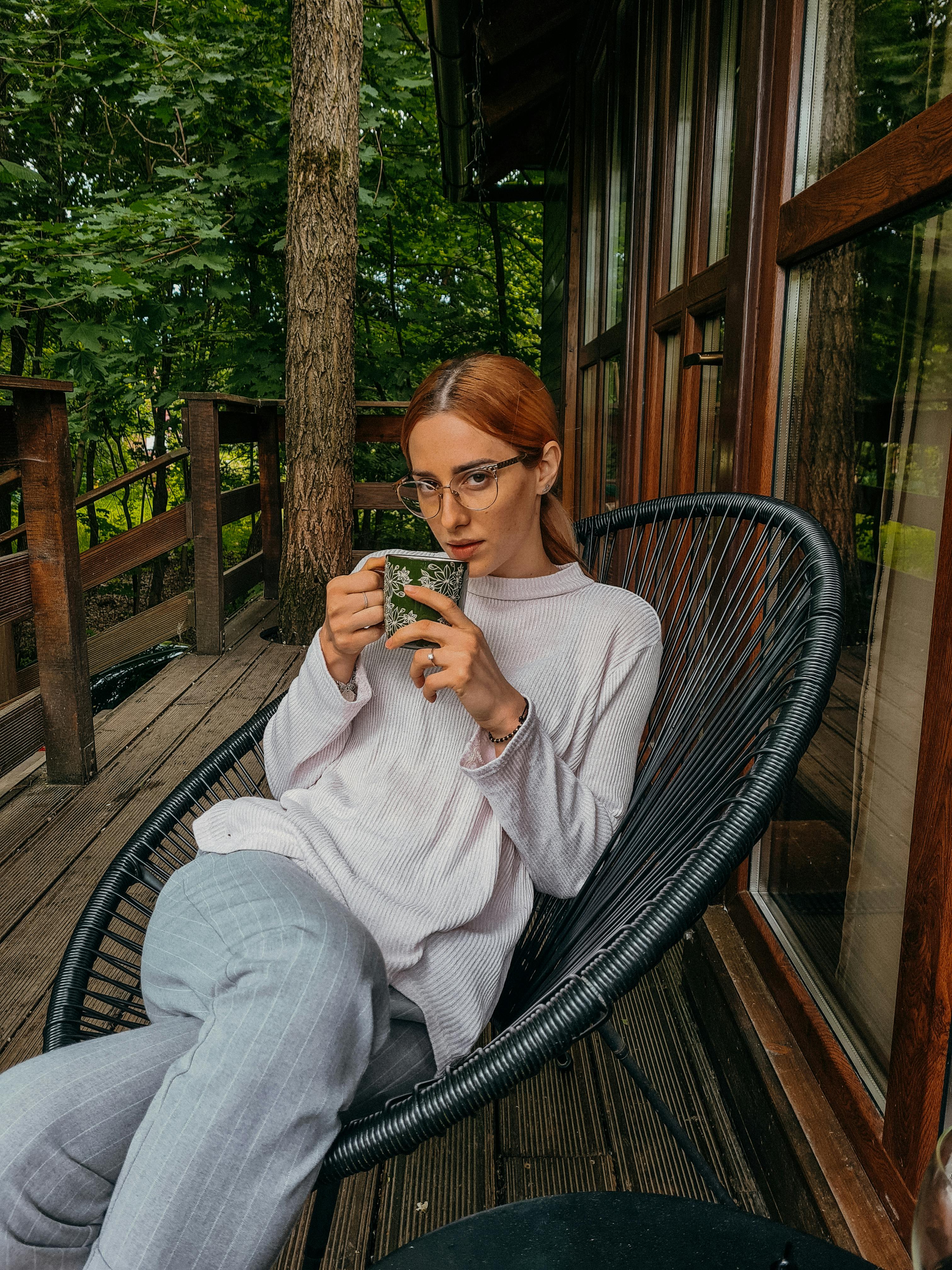 Eine Frau sitzt mit Tee auf ihrer Veranda | Quelle: Pexels