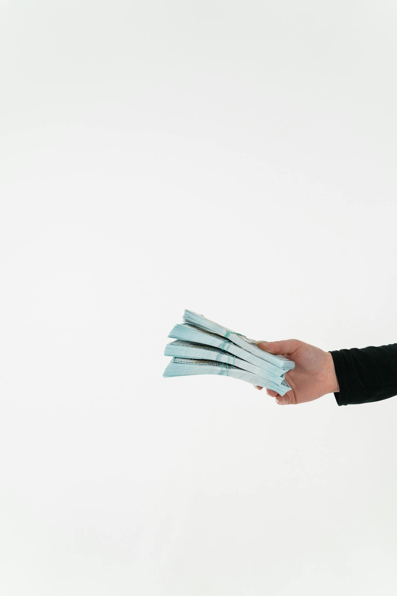 Eine Frau hält ein Geldbündel in der Hand | Quelle: Pexels