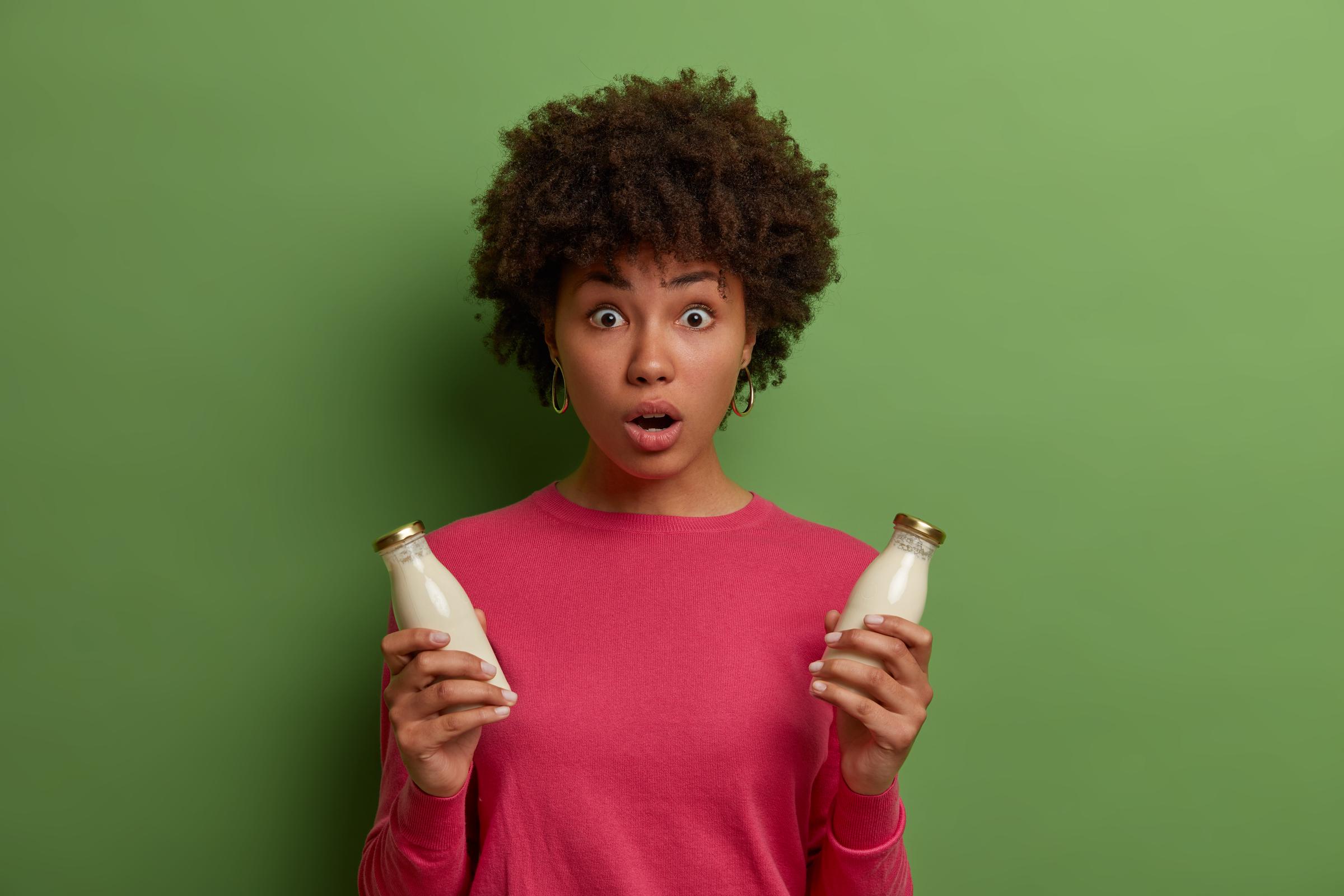 Eine geschockte Frau mit Milch in der Hand | Quelle: Freepik