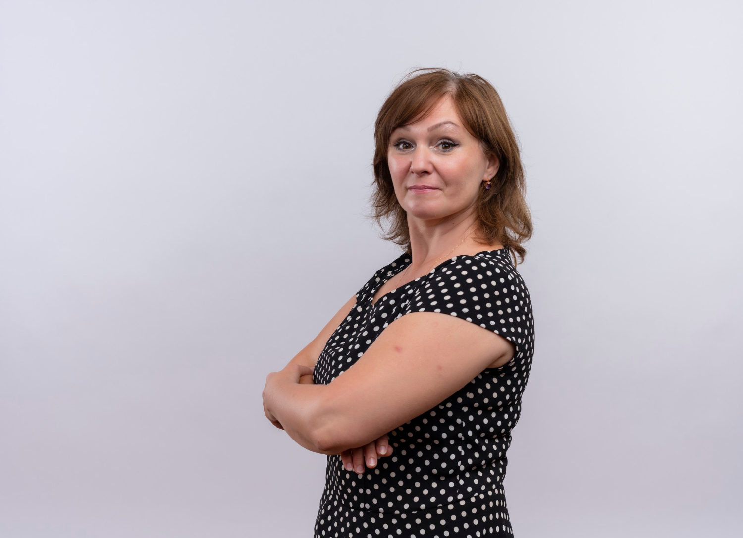 Eine Frau lächelt mit verschränkten Armen | Quelle: Freepik