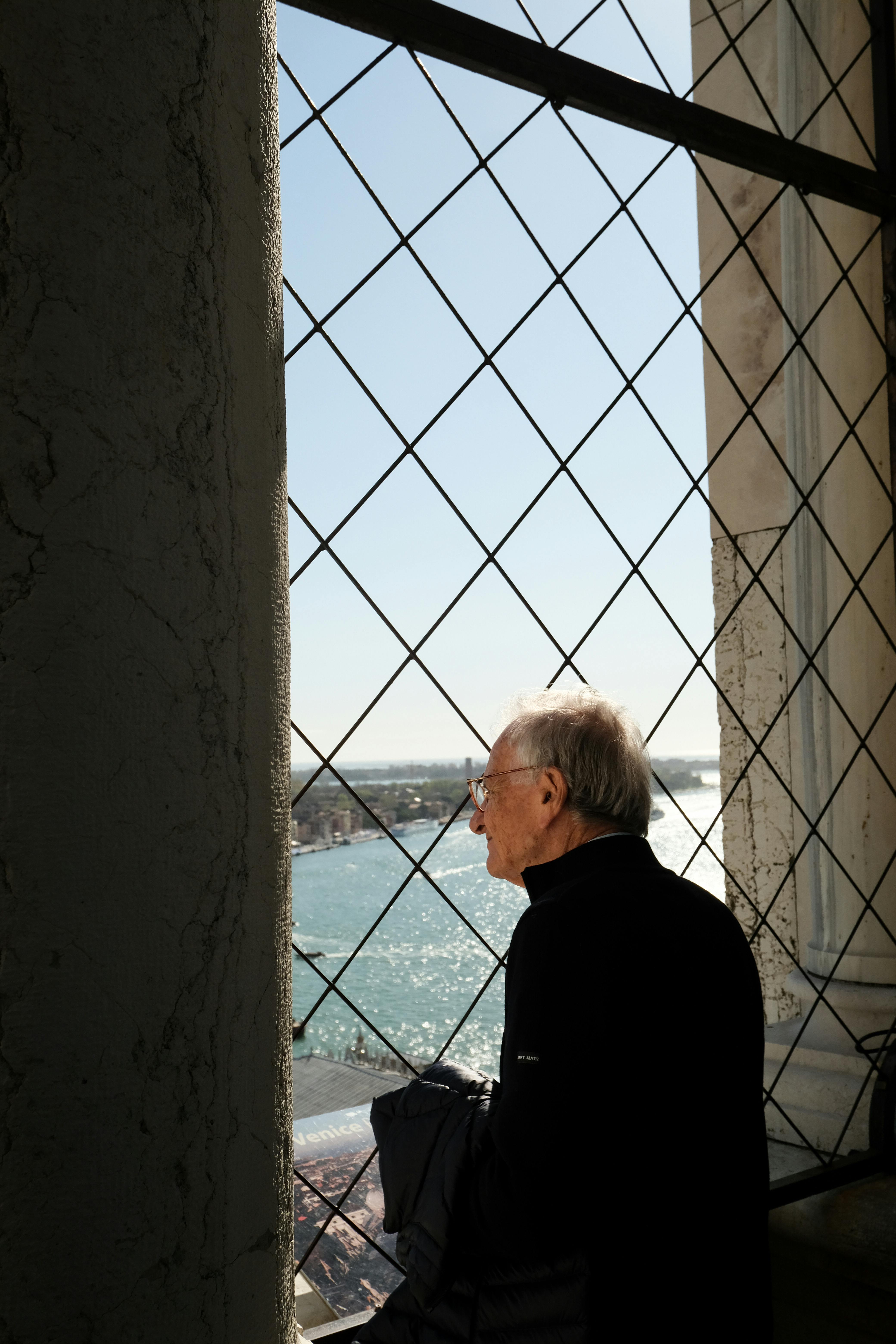 Älterer Mann, der aus dem Fenster blickt | Quelle: Pexels