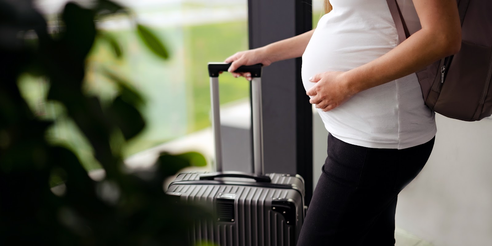 Eine schwangere Frau mit einem Koffer | Quelle: Shutterstock