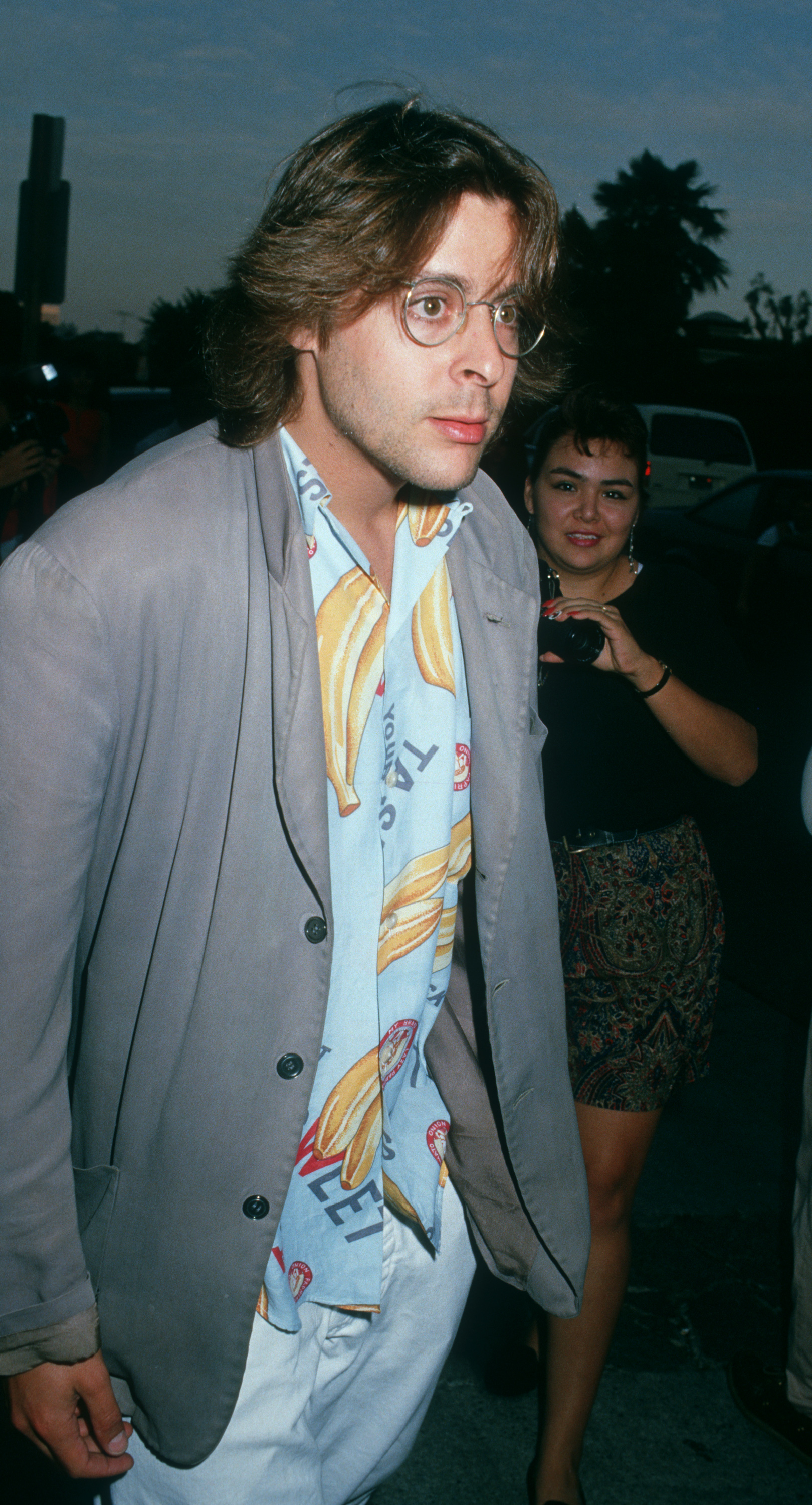 Der Schauspieler, der in einem Hemd mit Bananenmuster, einer Drahtbrille und einem grauen Blazer einen lässigen Look der späten Achtziger präsentiert, kommt im UA Coronet Theater in Westwood zur Premiere von