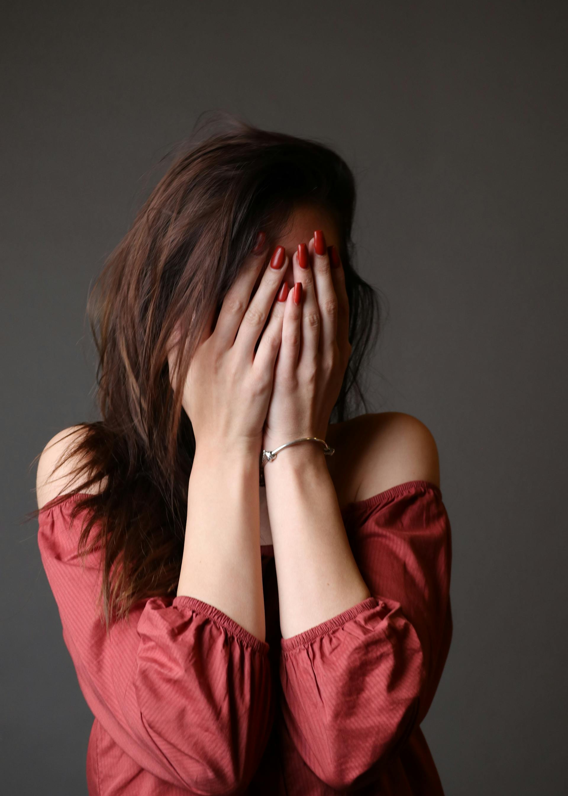 Eine Frau, die ihr Gesicht mit ihren Händen bedeckt | Quelle: Pexels