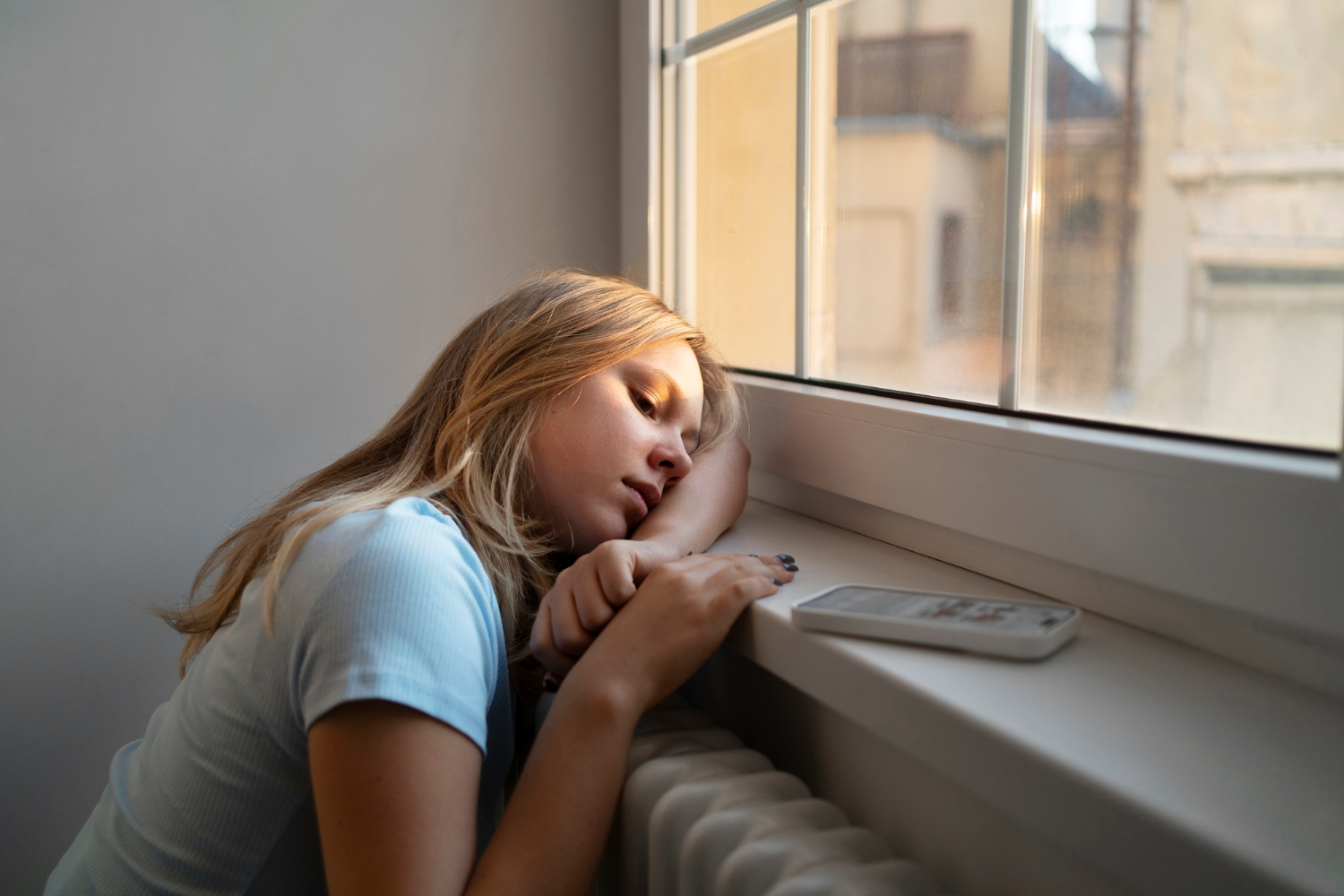 Ein trauriges Teenager-Mädchen sitzt am Fenster | Quelle: Freepik