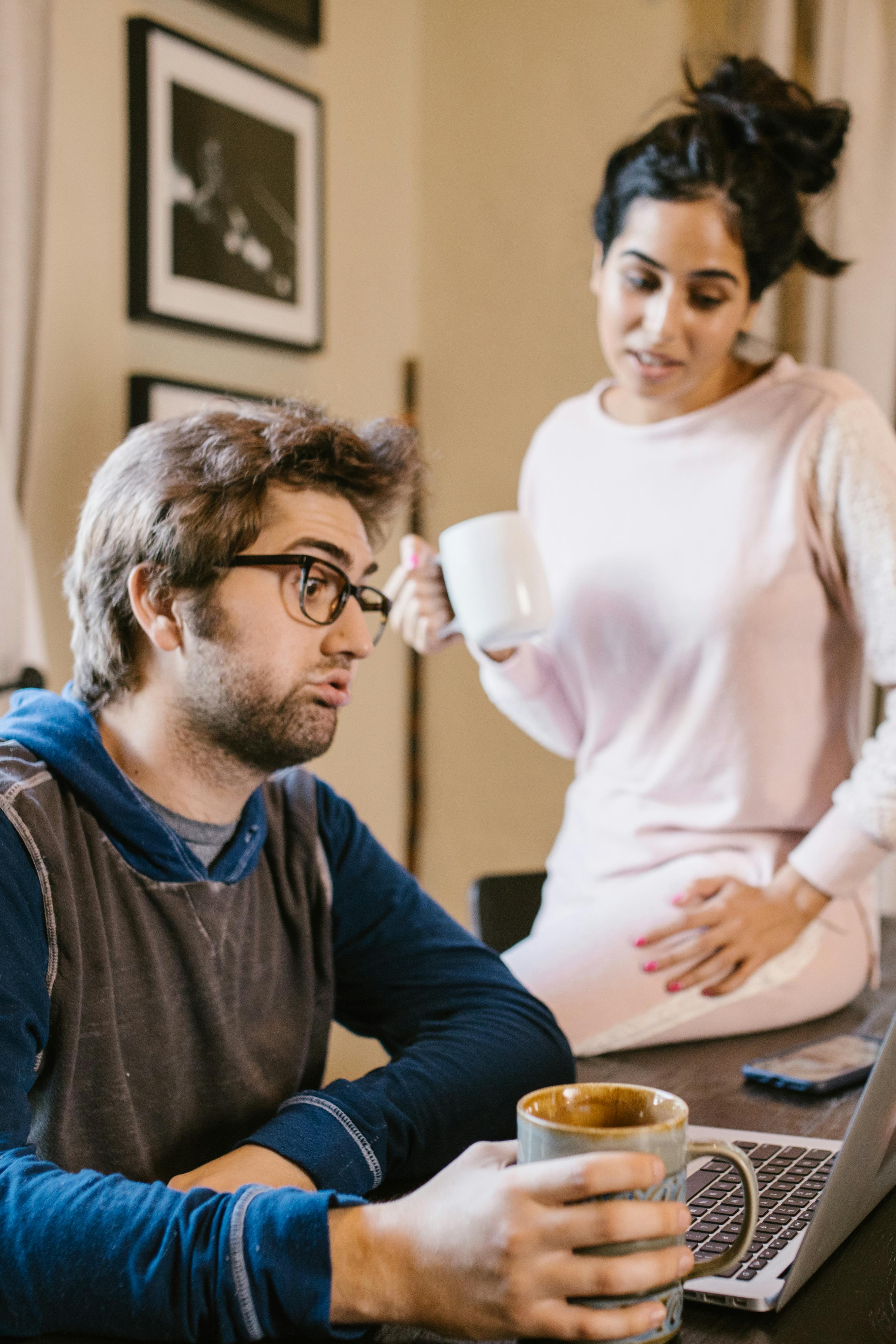 Ein Paar unterhält sich, während es auf einen Laptop schaut | Quelle: Pexels