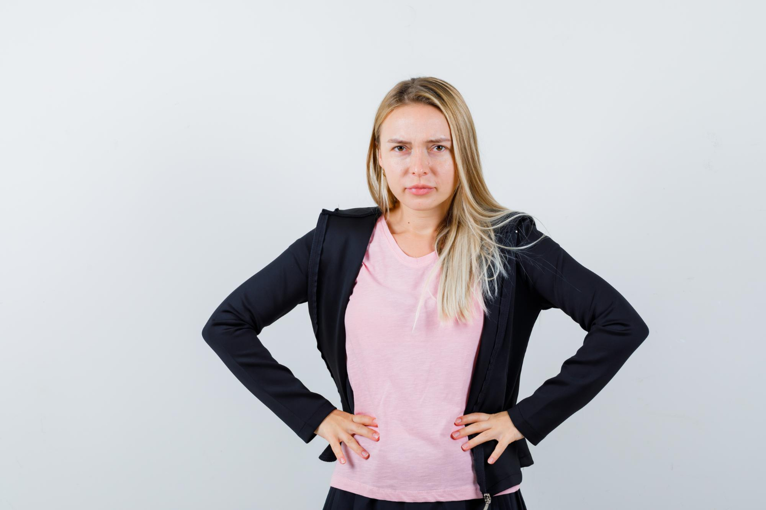 Eine verärgerte Frau mit den Händen in der Hüfte | Quelle: Freepik