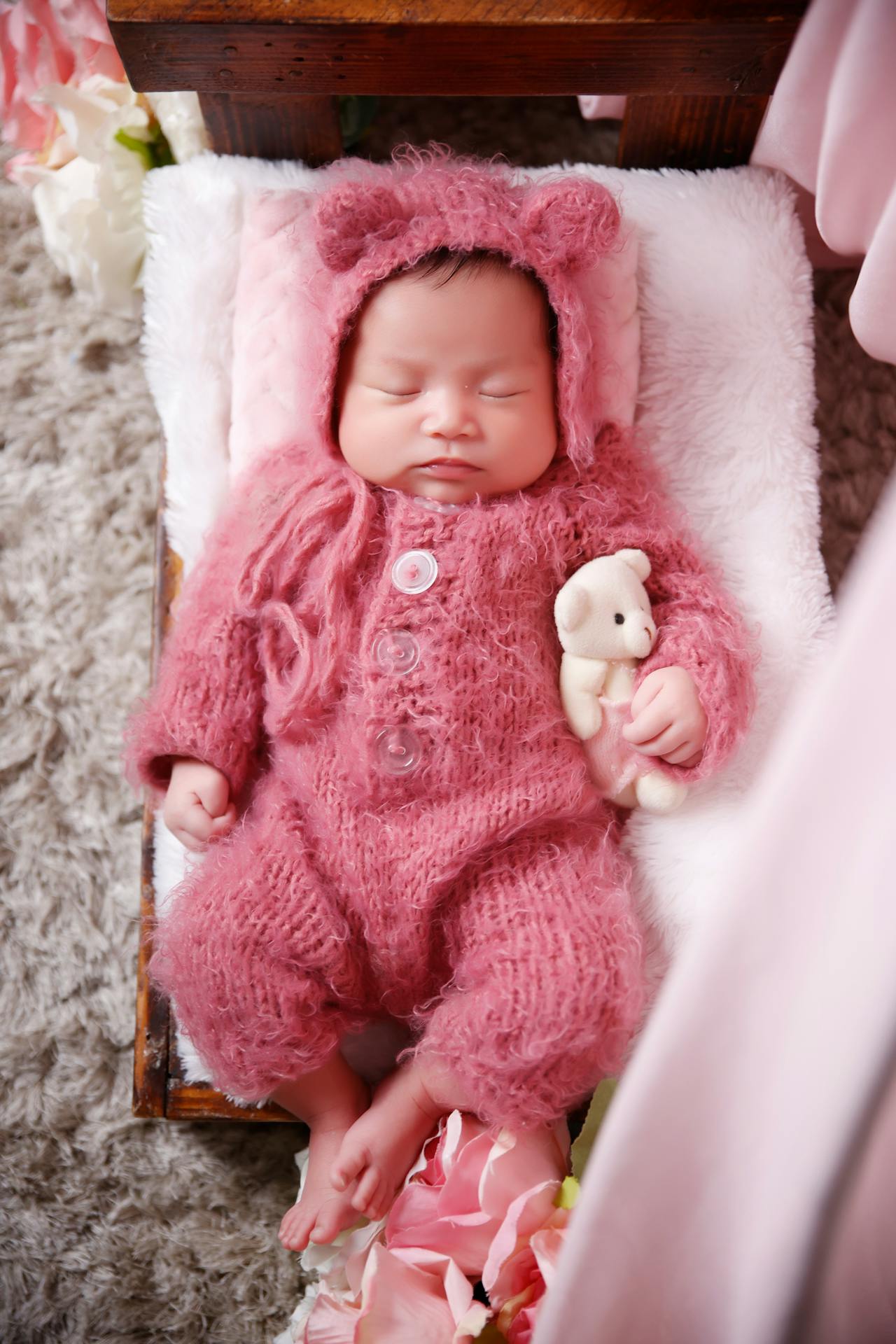 Ein süßes Baby, das sich schlafend an einen Teddybär schmiegt | Quelle: Pexels