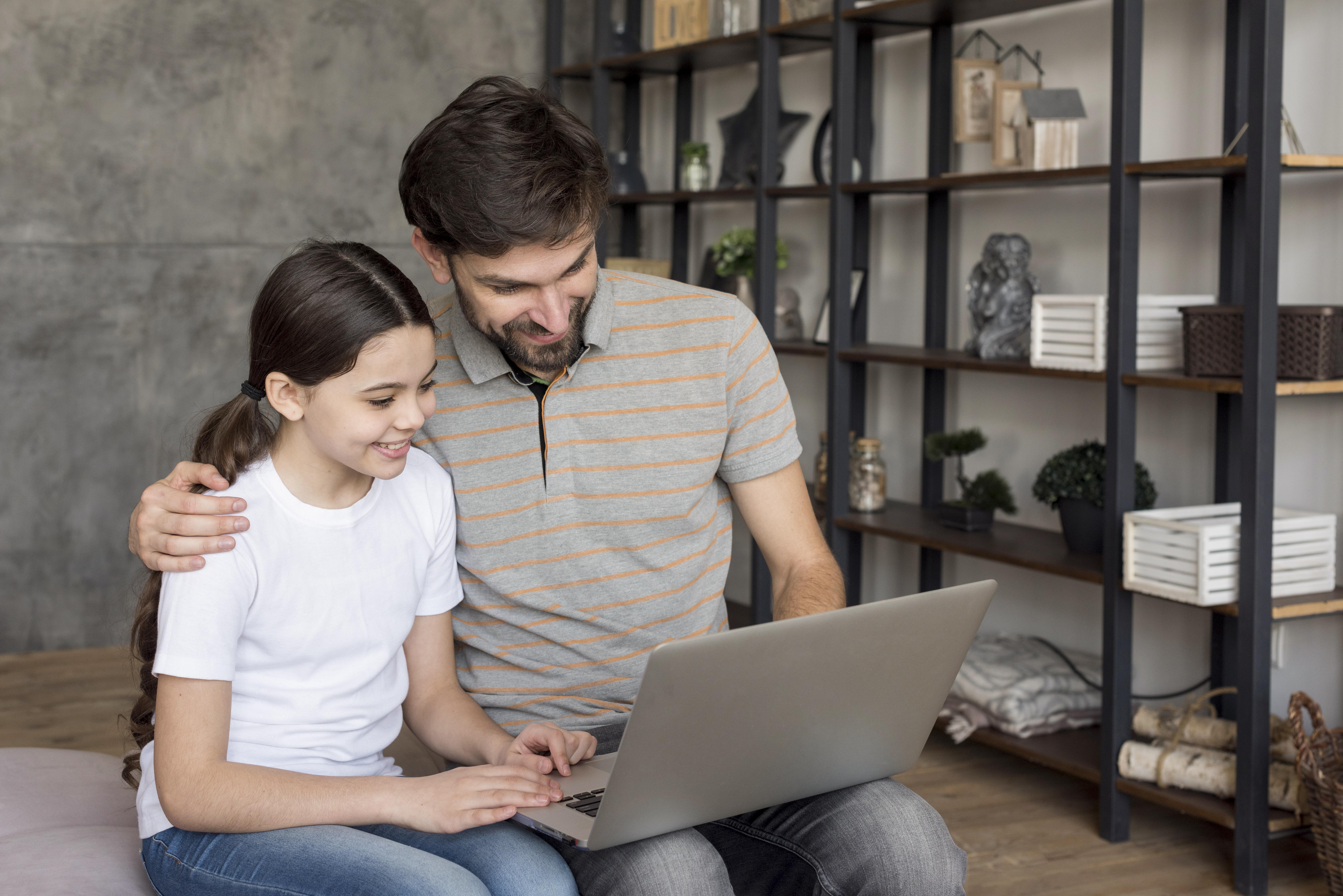 Ein Mädchen und ihr Vater benutzen einen Laptop | Quelle: Freepik