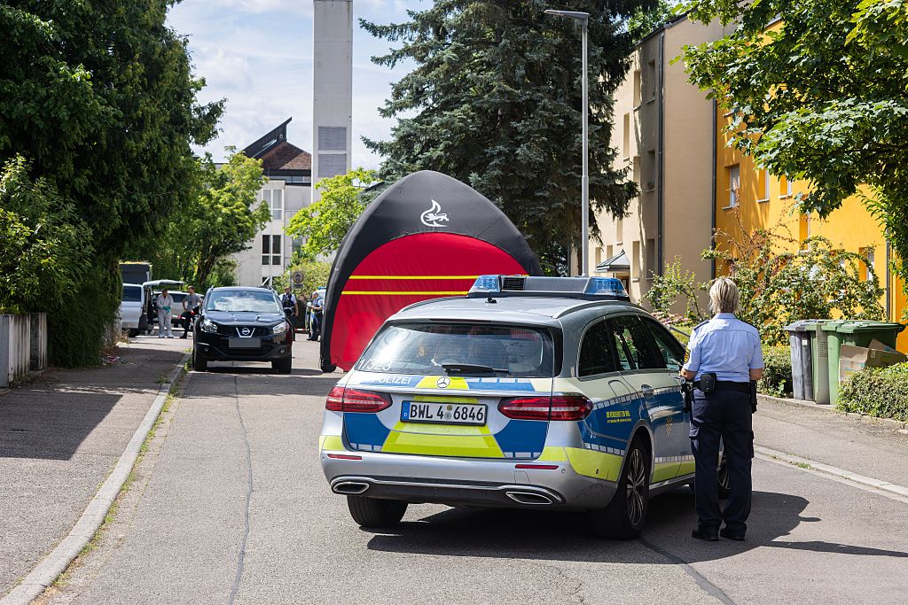 06. Juli 2026, Baden-Württemberg, Offenburg: Beamte der Kriminalpolizei und der Kriminaltechnik stehen an einem Tatort, im Vordergrund ist ein Polizeieinsatzfahrzeug zu sehen. Nach einer Schießerei in einem Wohngebiet wird vermutet, dass eine der beiden getöteten Personen ein Verdächtiger war. | Quelle: Getty Images