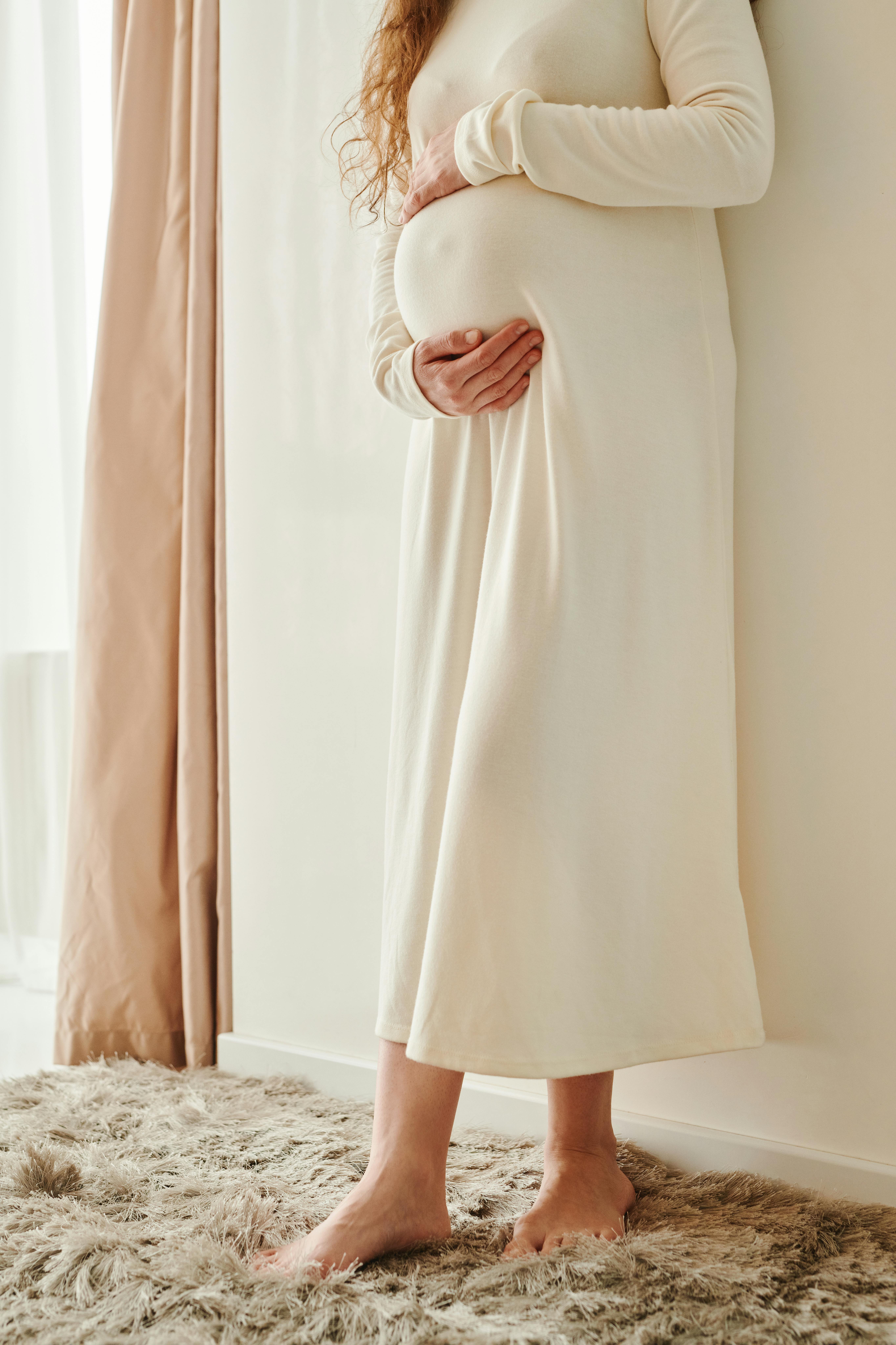 Eine schwangere Frau, die ihren Bauch wiegt | Quelle: Pexels