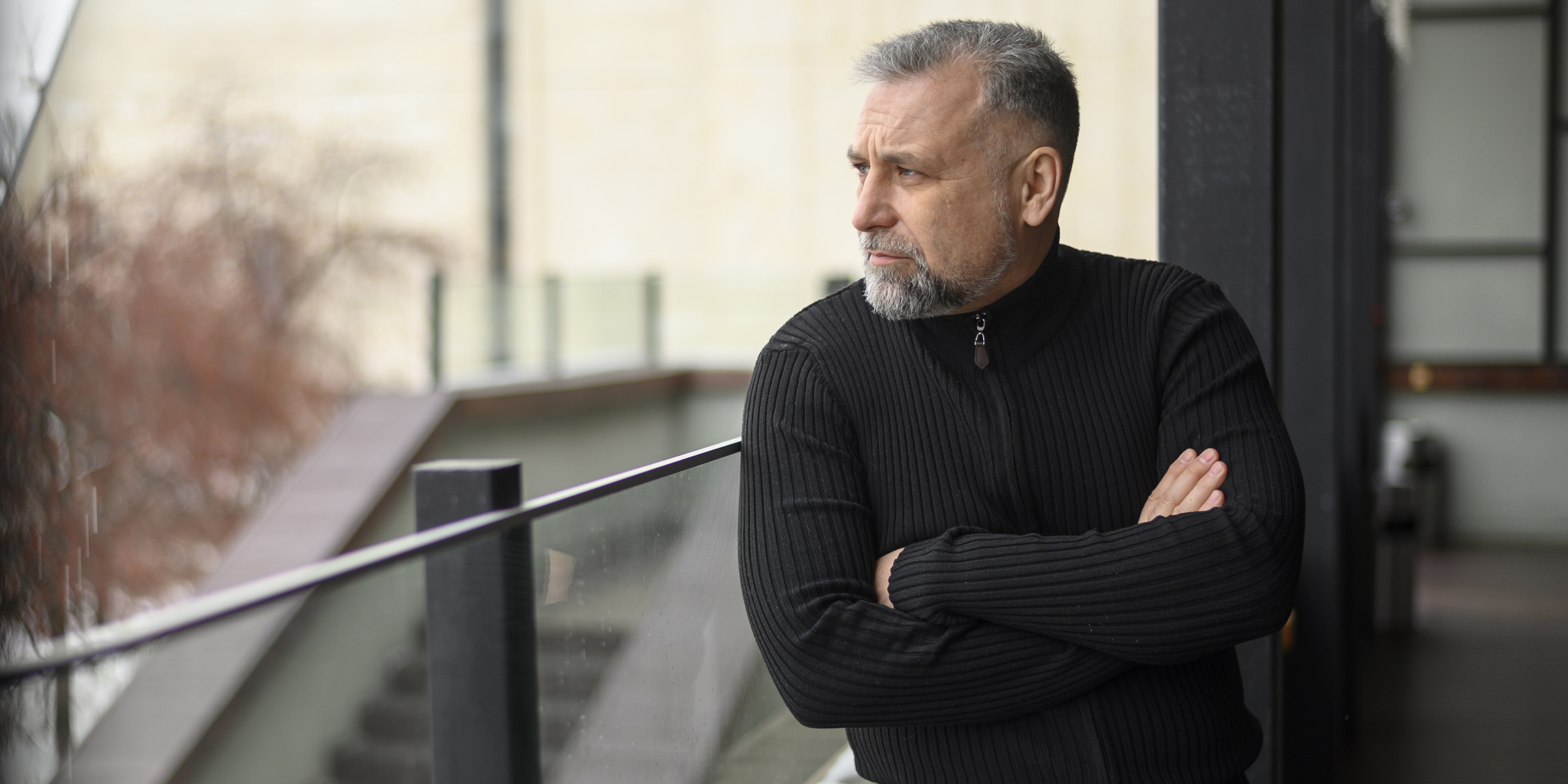 Ein strenger Mann steht auf einem Balkon | Quelle: Freepik