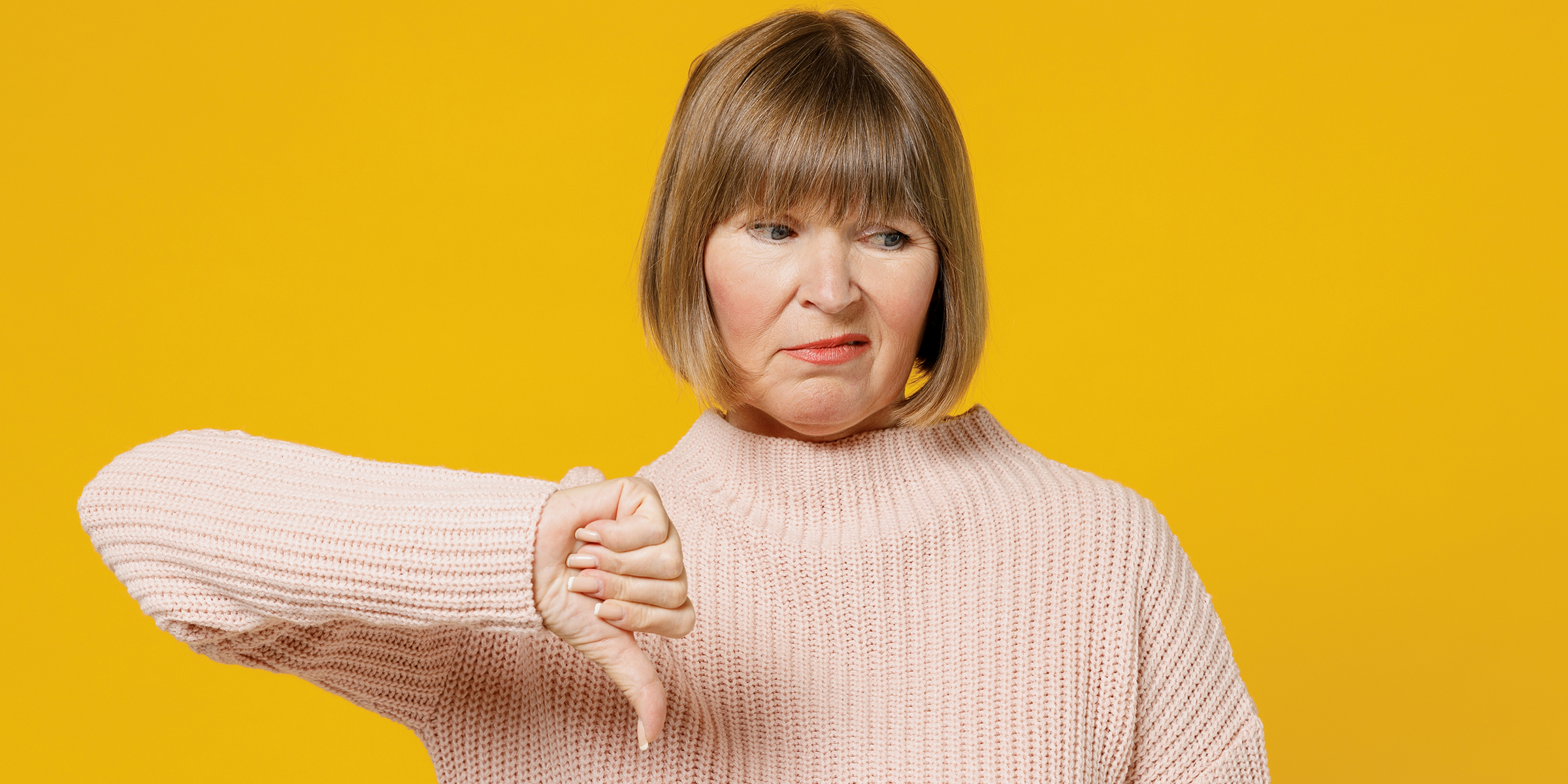 Eine unglückliche Frau, die ein Daumen-nach-unten-Zeichen macht | Quelle: Shutterstock