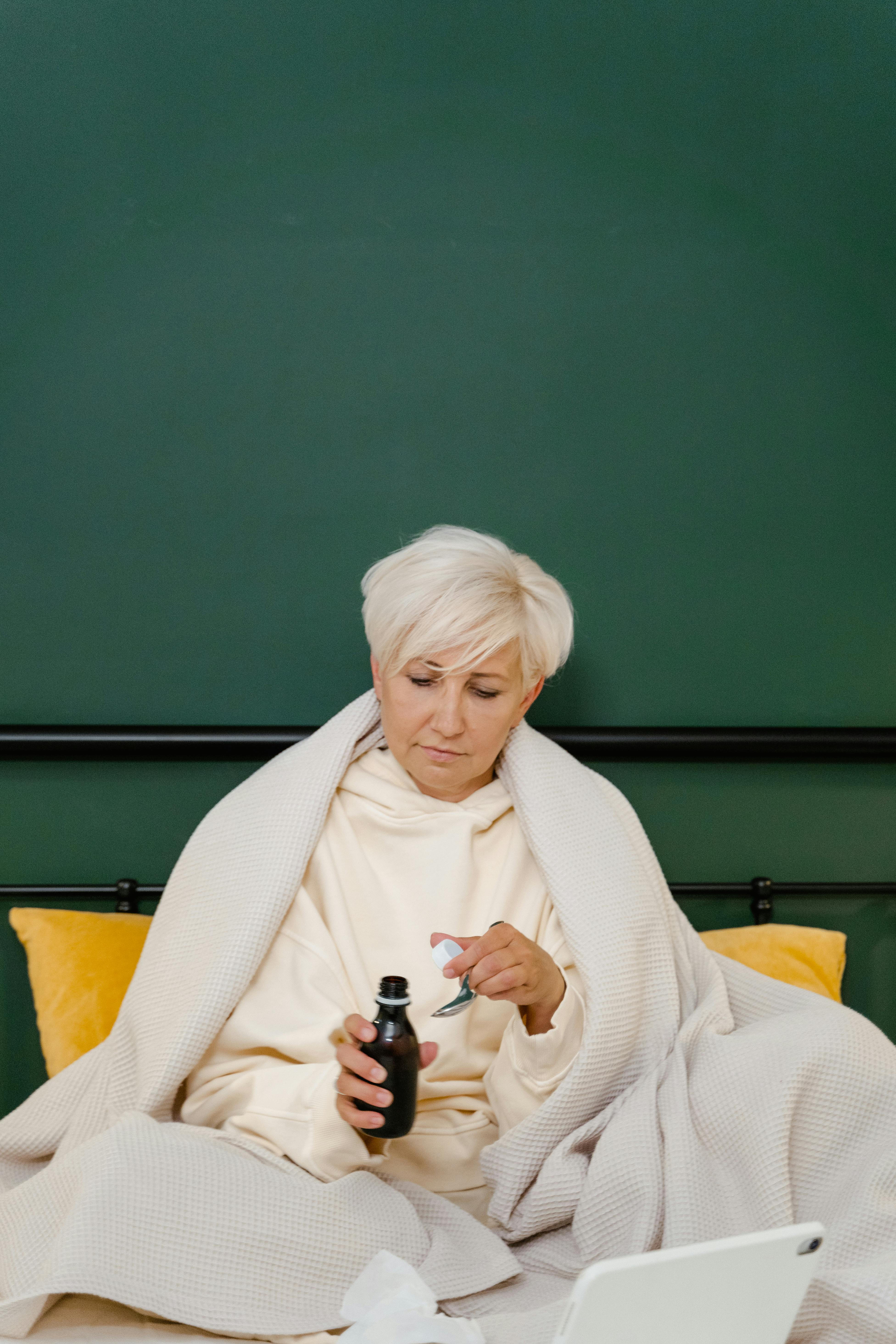 Eine Frau, die im Bett über Medizin spricht | Quelle: Pexels