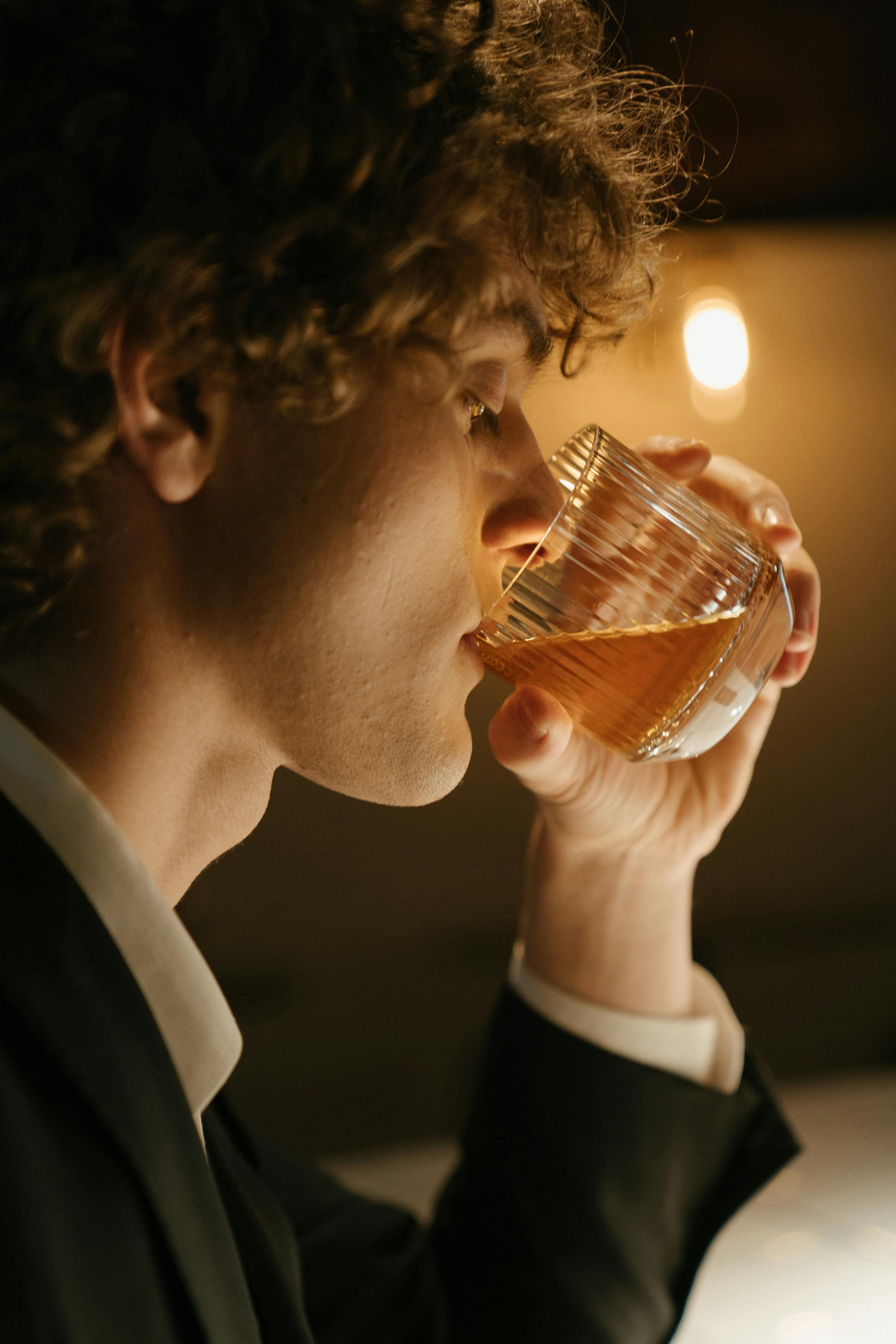 Ein Mann, der aus einem Glas trinkt | Quelle: Pexels