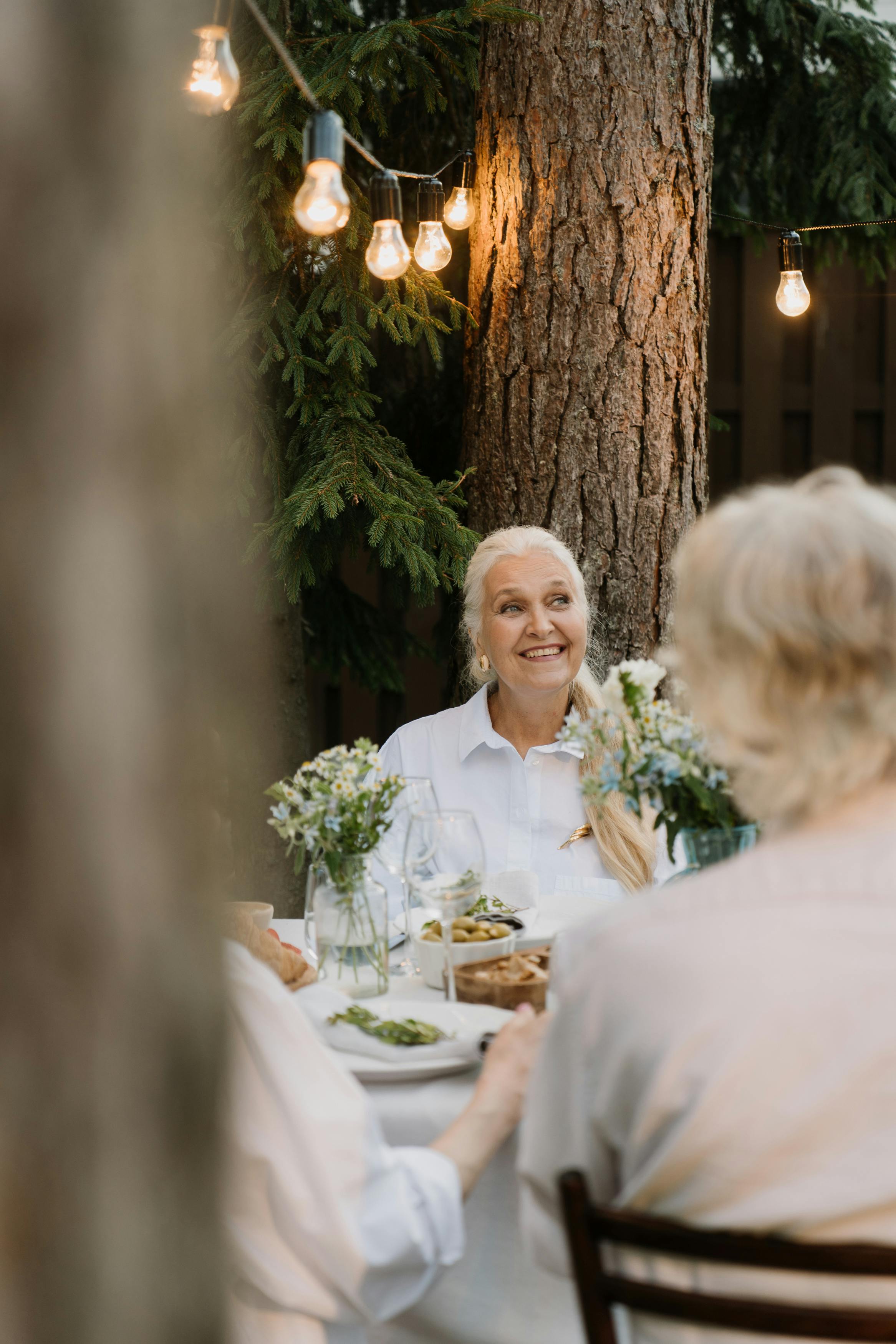 Eine glückliche Frau, die eine Mahlzeit mit anderen genießt | Quelle: Pexels