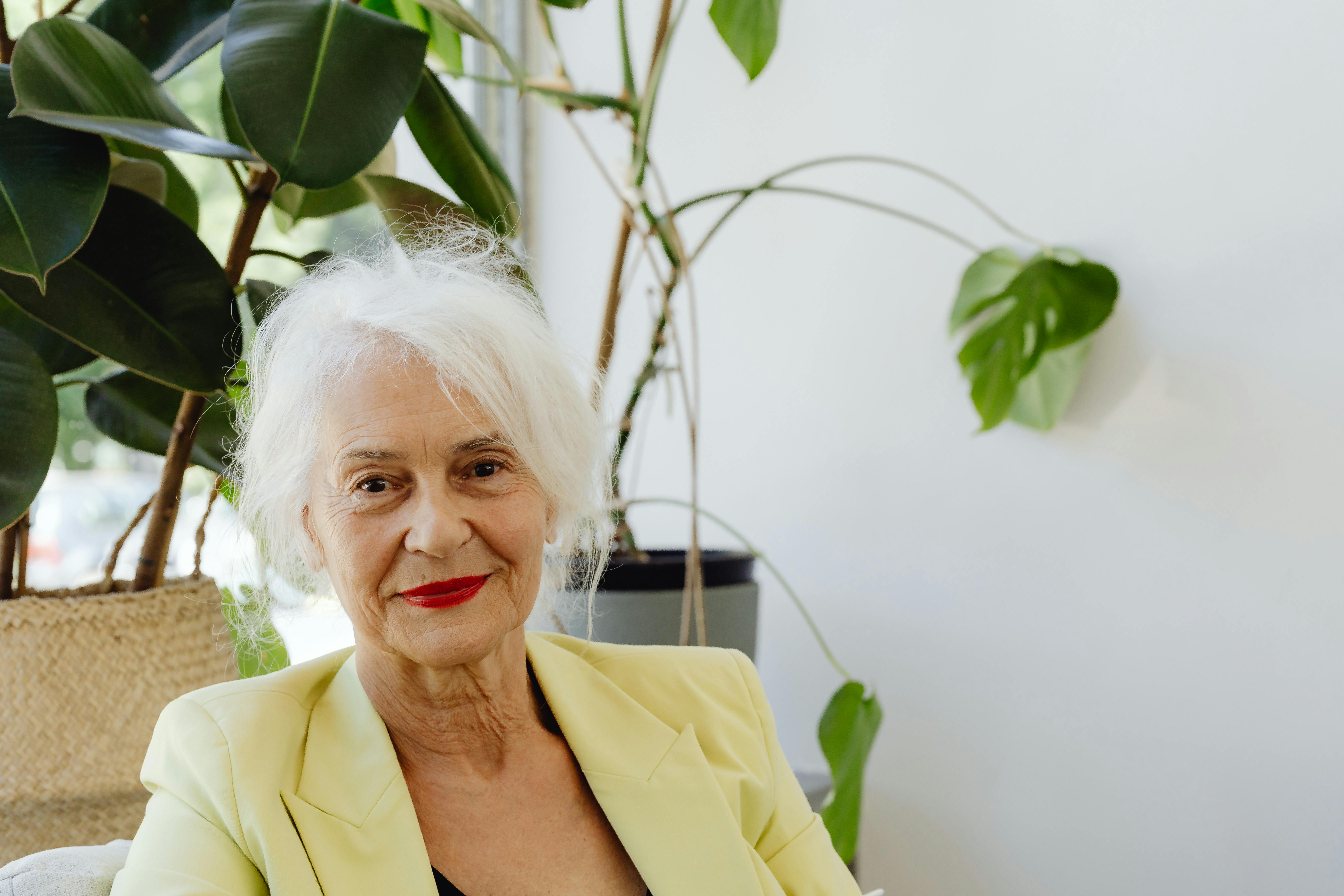 Eine lächelnde alte Dame mit einem gelben Blazer | Quelle: Pexels