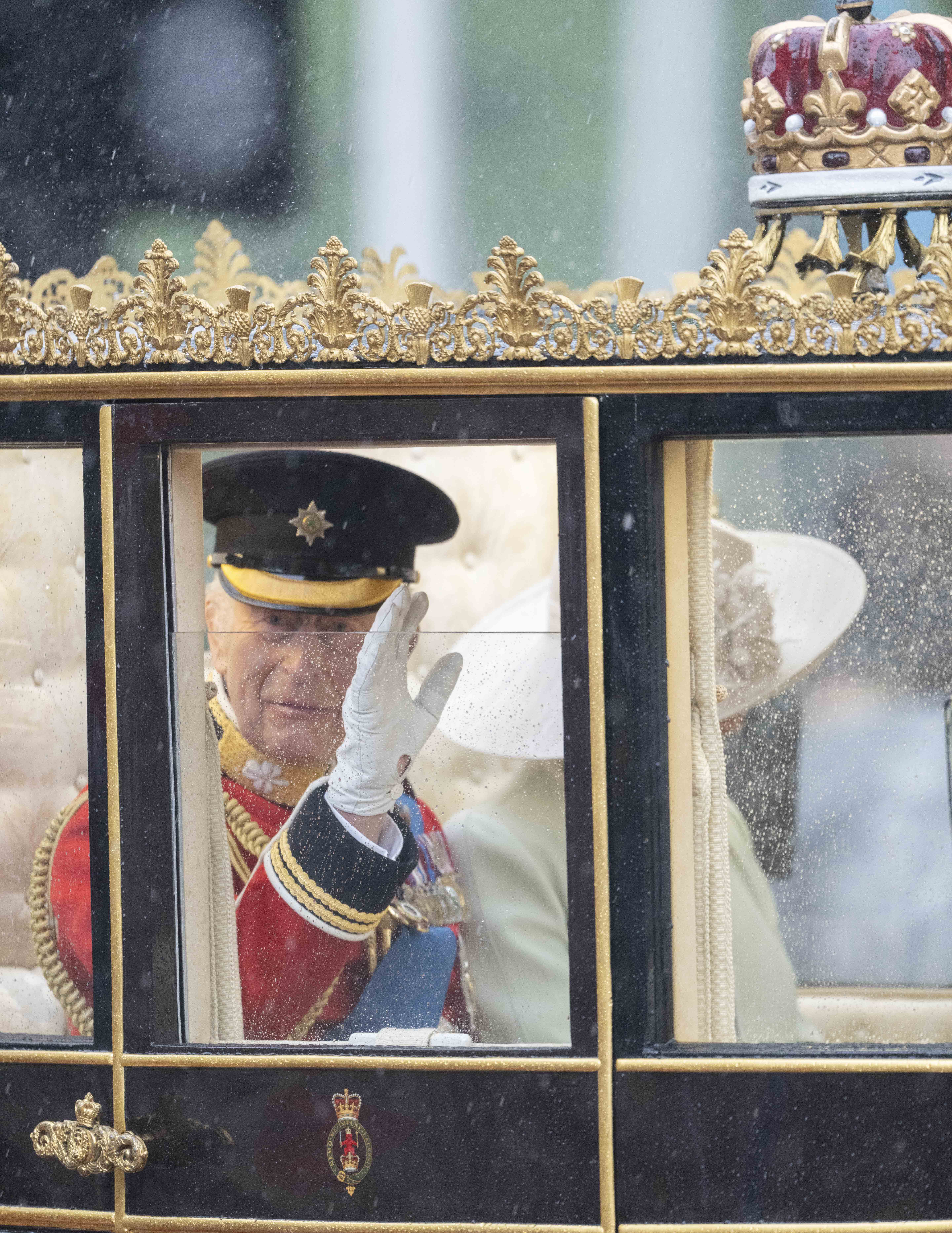 Durch regengesprenkeltes Glas erkennt König Karl III. die Schaulustigen während des Trooping the Colour-Zuges am 15. Juni 2024 an | Quelle: Getty Images