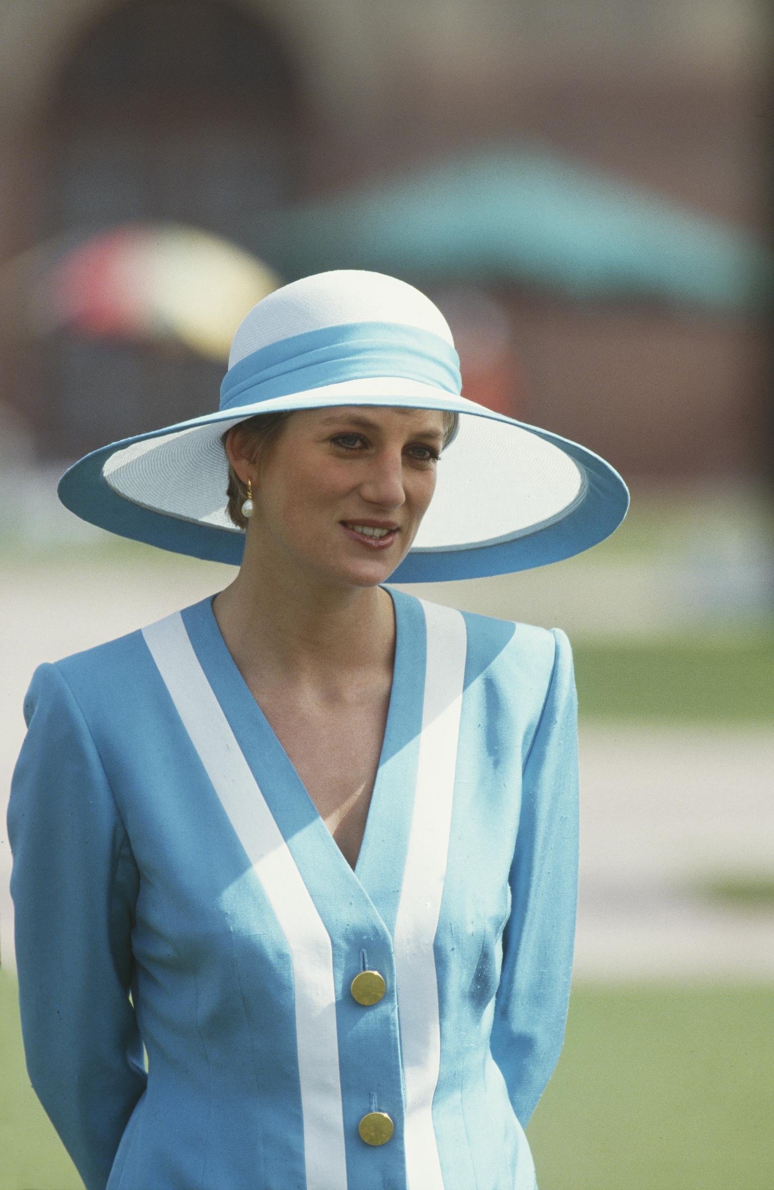 Prinzessin Diana steht am 12. Februar 1992 mit ruhiger Eleganz im Rashtrapati Bhavan in Neu-Delhi. In einem auffälligen blau-weißen Catherine-Walker-Anzug und einem Philip-Somerville-Hut verkörpert die verstorbene Königin bei ihrem Besuch im indischen Präsidentenpalast vornehme Diplomatie.