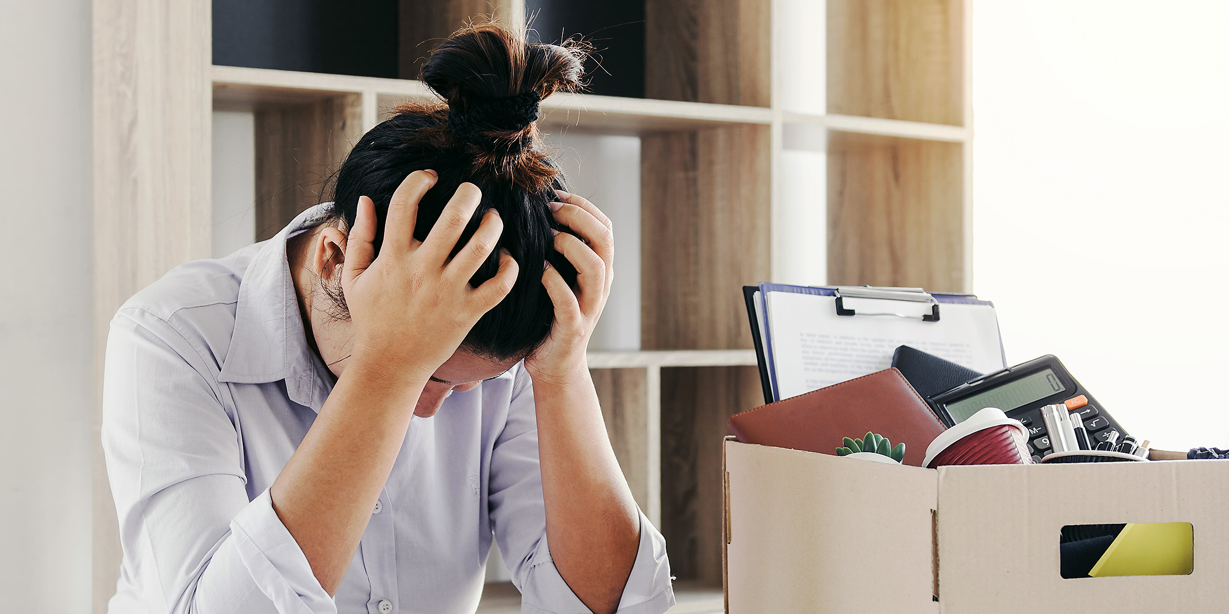 Eine gestresste Frau sitzt in ihrem Büro | Quelle: Shutterstock