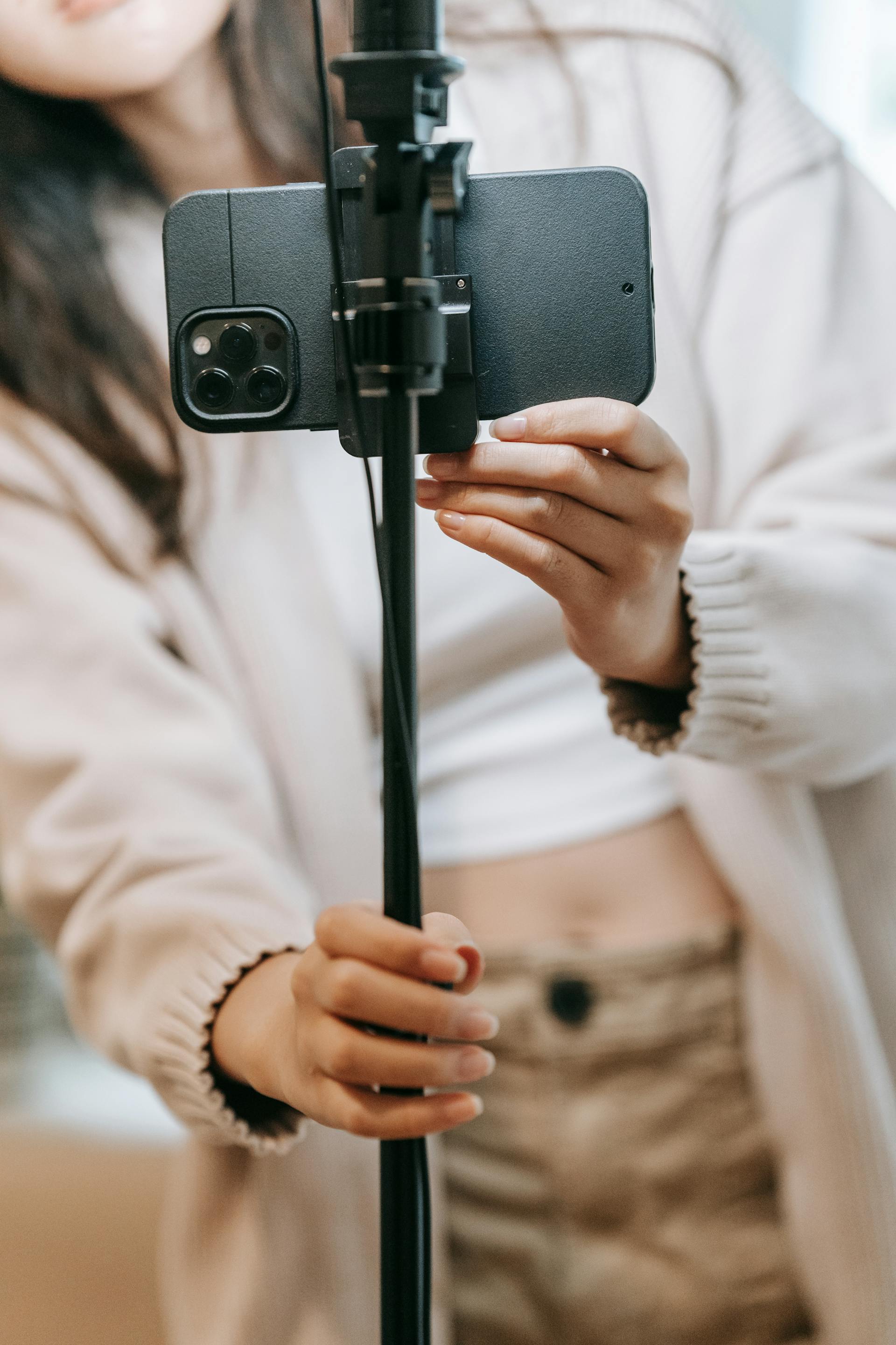 Jemand hält ein Telefon an einem Selfie-Stick | Quelle: Pexels