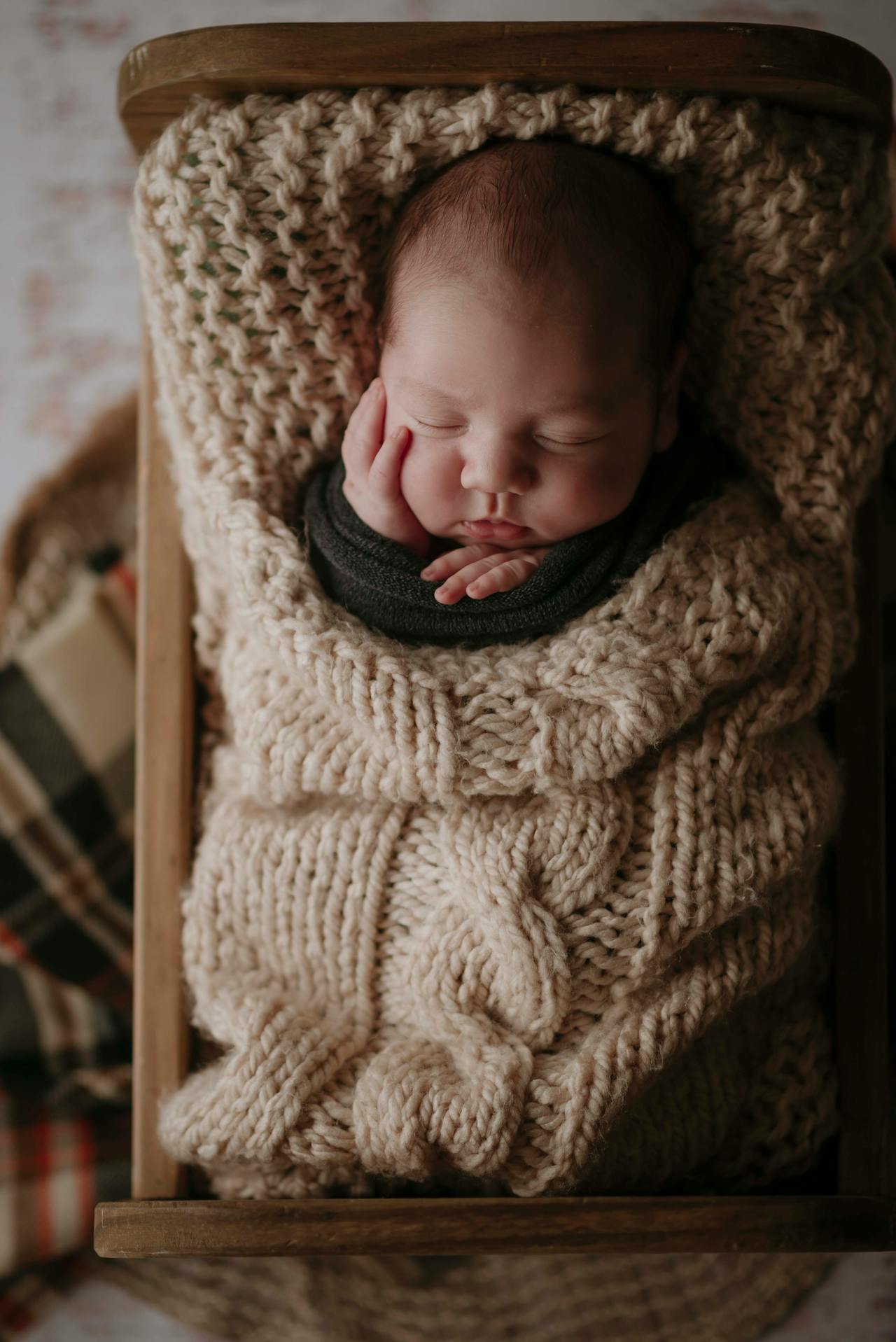 Ein Baby, eingewickelt in eine cremefarbene Strickdecke | Quelle: Pexels