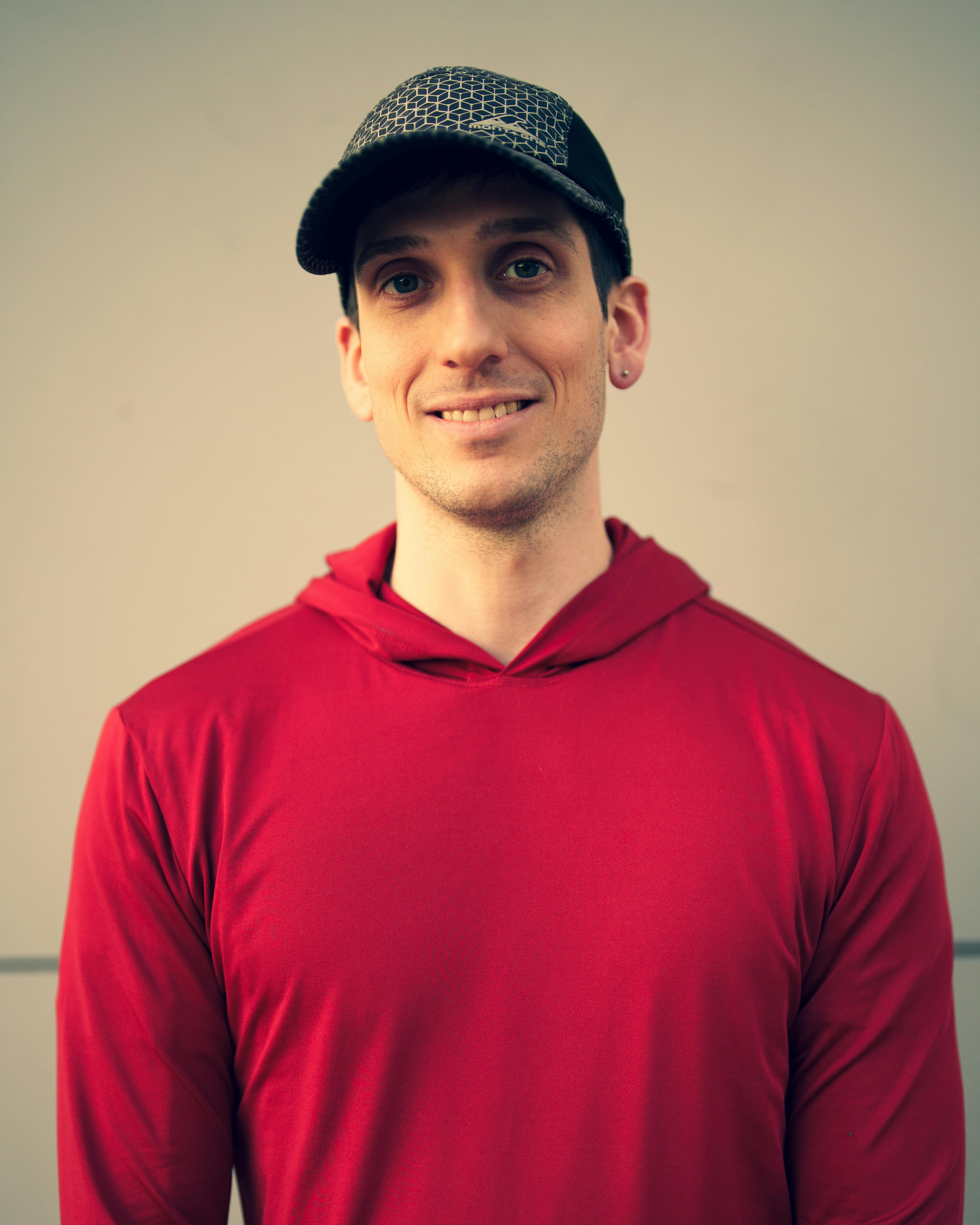 Ein lächelnder Mann in einem roten Hoodie | Quelle: Pexels