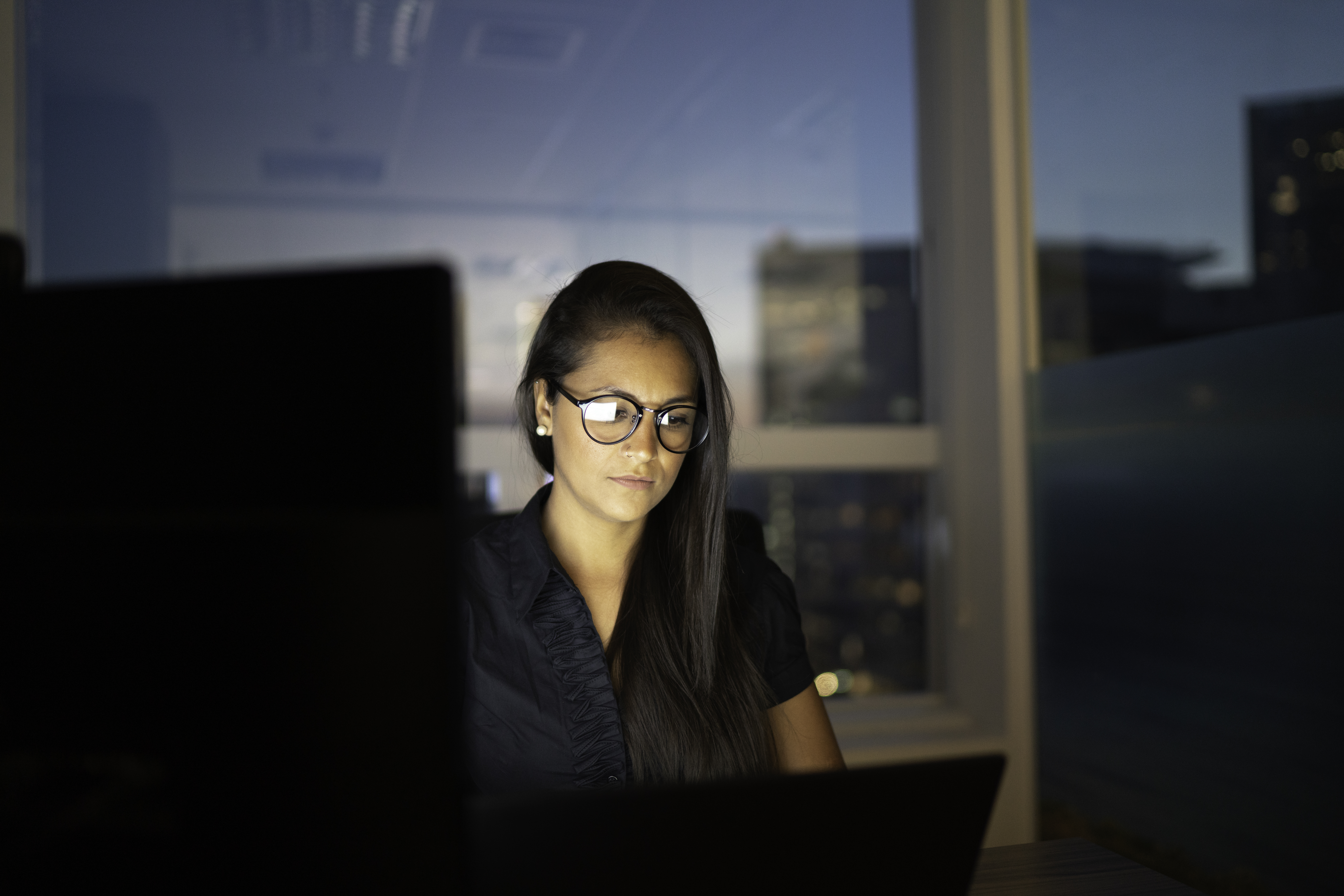 Geschäftsfrau, die bis spät in die Nacht im Büro arbeitet | Quelle: Getty Images