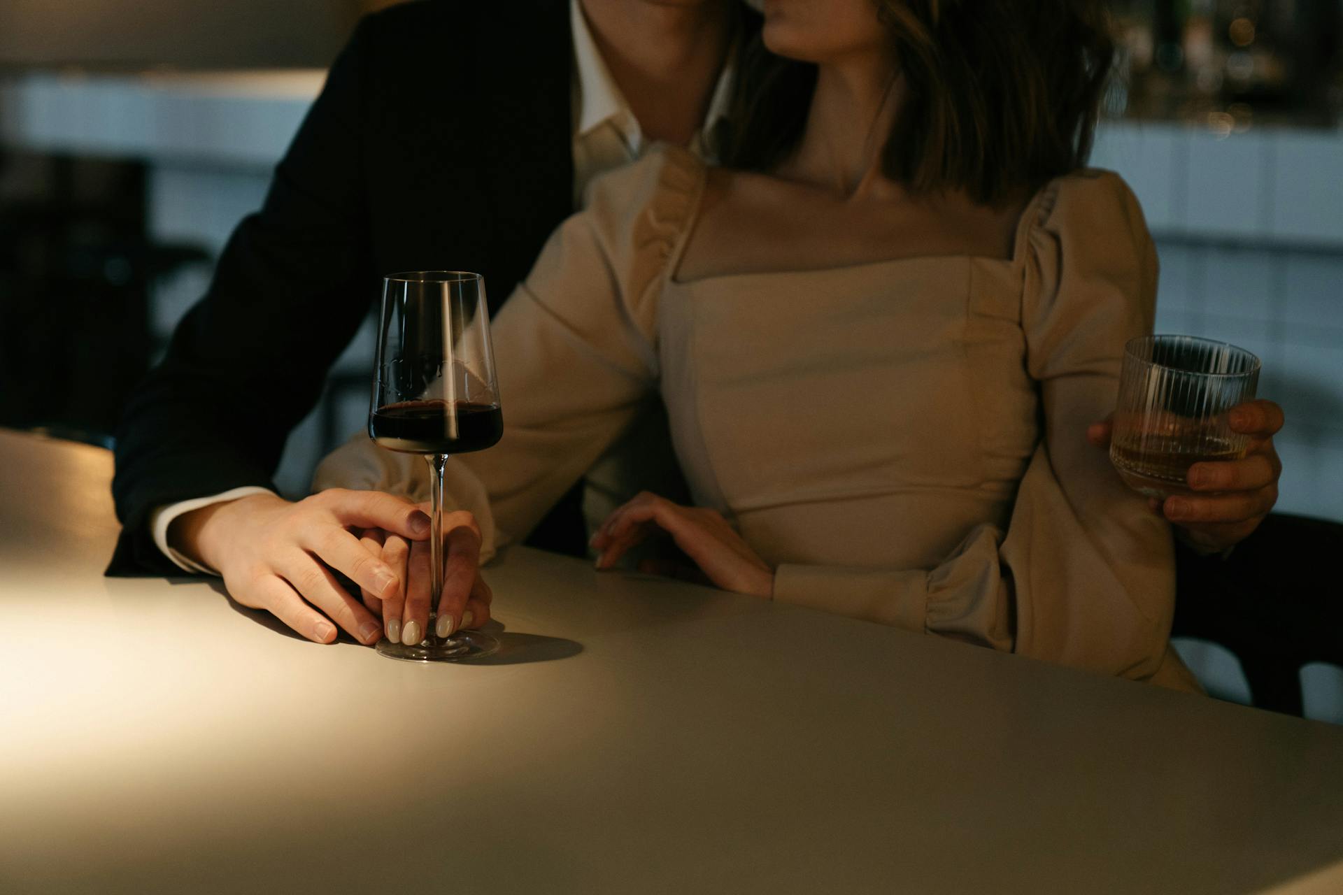 Eine Nahaufnahme eines Paares, das es sich bei einem Drink in einer Bar gemütlich macht | Quelle: Pexels