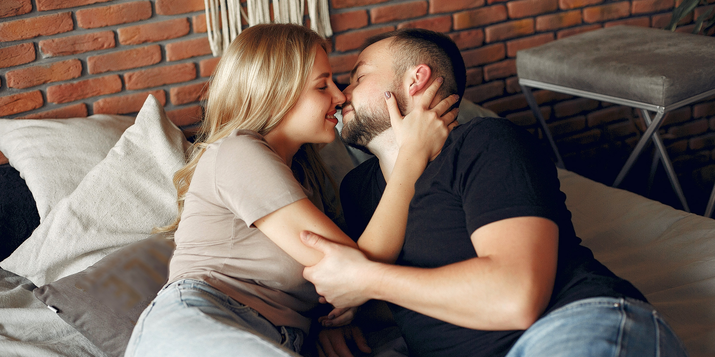 Ein romantisches Paar, das auf der Couch liegt und sich gegenseitig umarmt | Quelle: Freepik