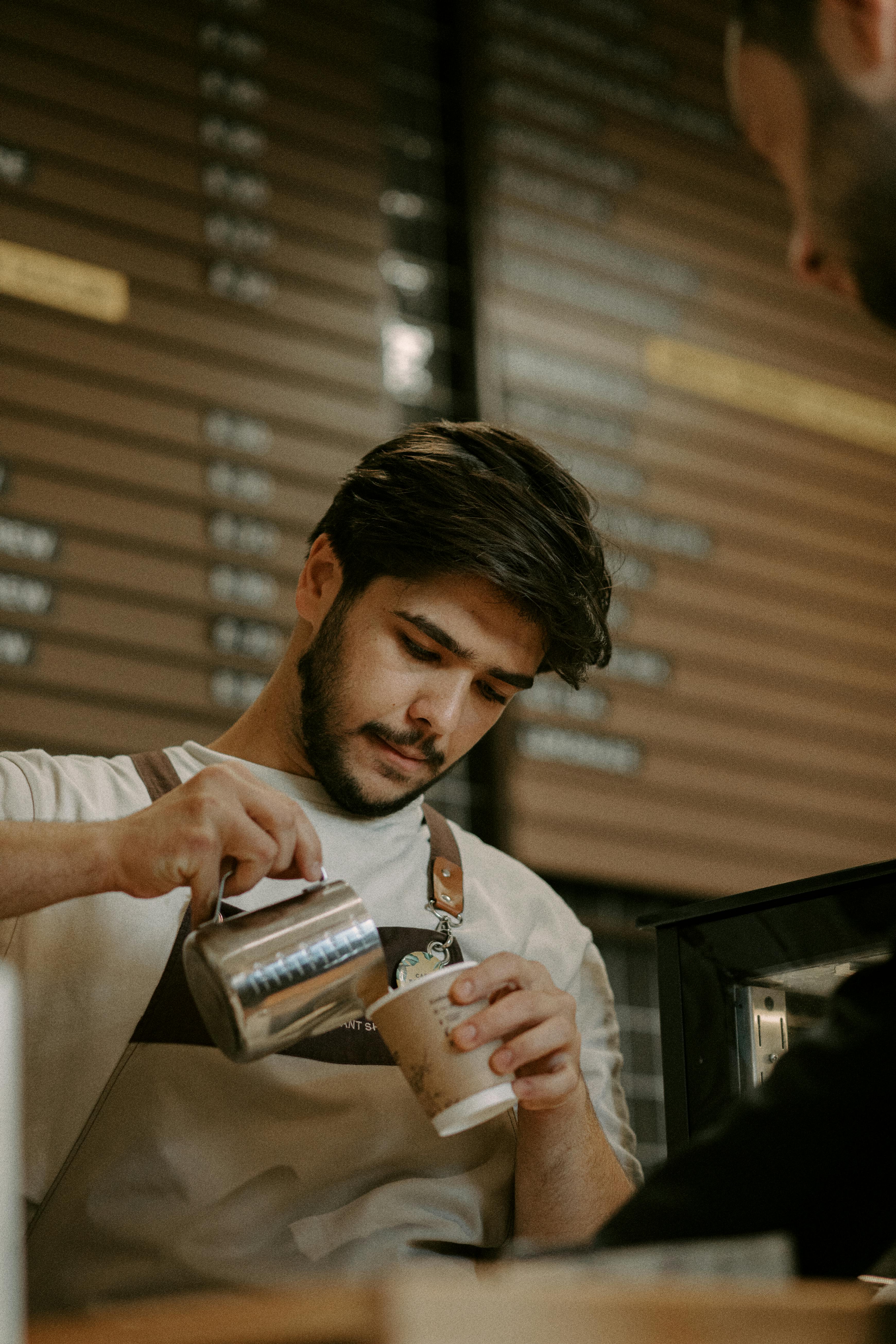 Barista gießt Milch in den Kaffee | Quelle: Pexels