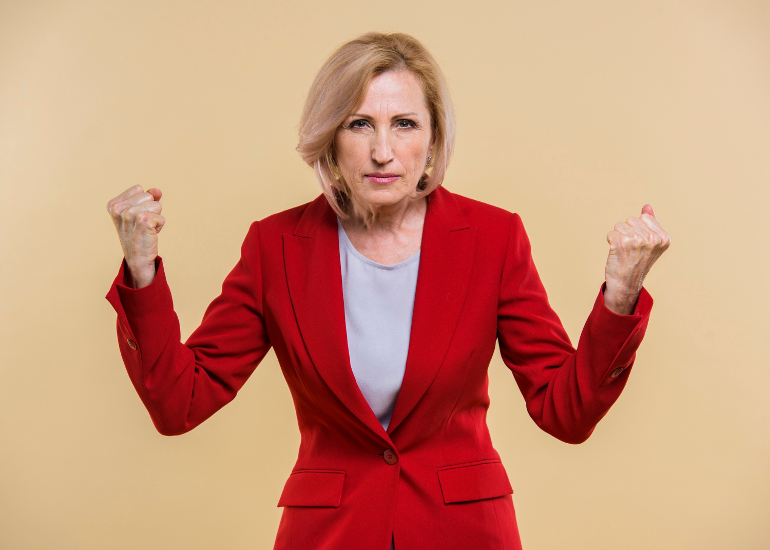 Eine wütende ältere Frau mit geballten Fäusten | Quelle: Freepik