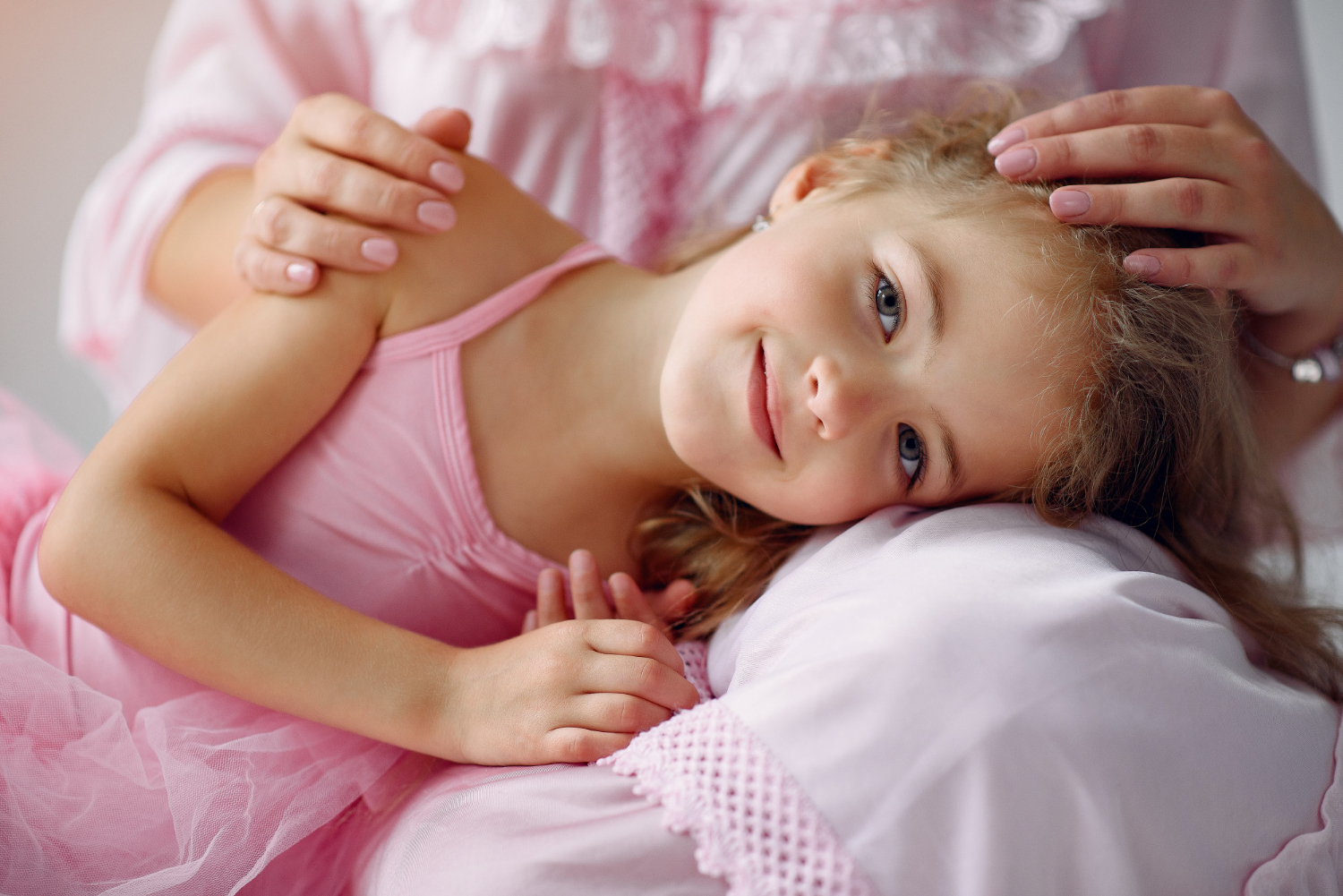 Ein kleines Mädchen, das auf dem Schoß seiner Mutter liegt | Quelle: Freepik