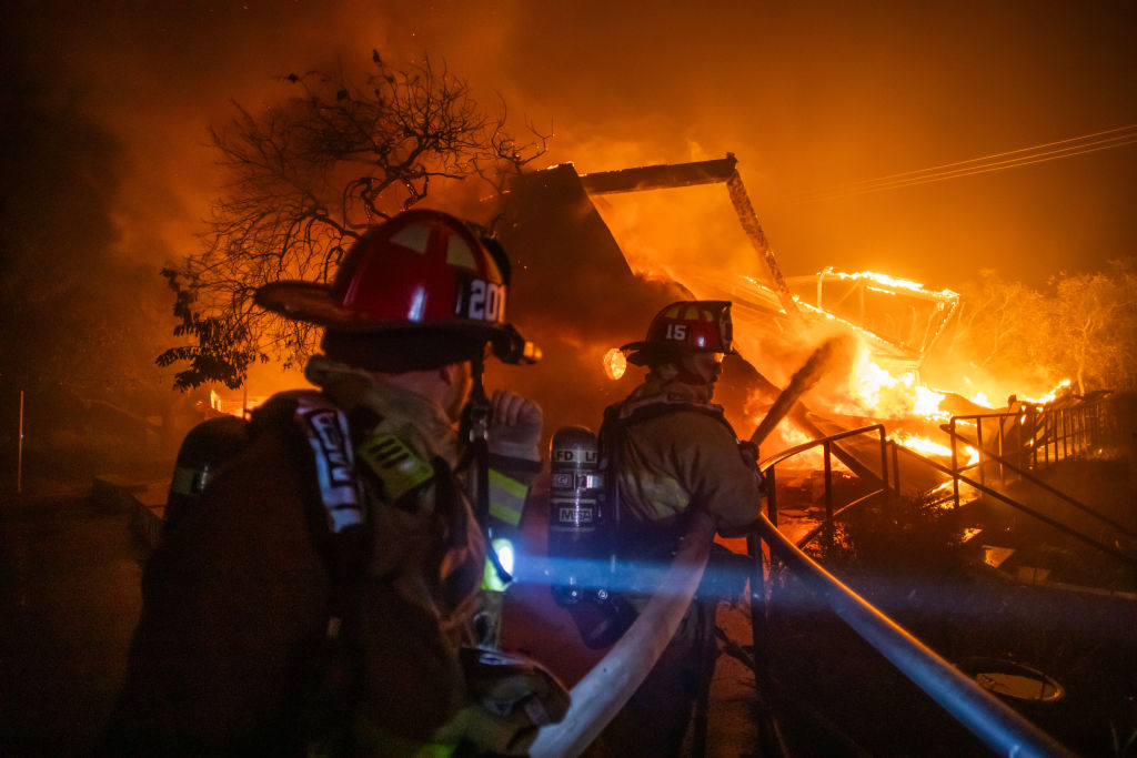 Feuerwehrleute bekämpfen die Flammen des Palisades-Feuers, das während eines heftigen Sturms am 8. Januar 2025 das Theatre Palisades im Stadtteil Pacific Palisades von Los Angeles, Kalifornien, in Brand gesetzt hat. | Quelle: Getty Images
