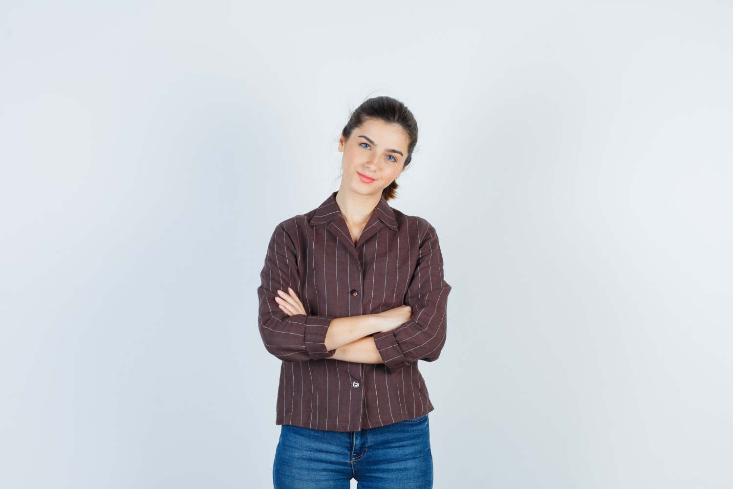Eine lächelnde junge Frau mit verschränkten Armen | Quelle: Freepik