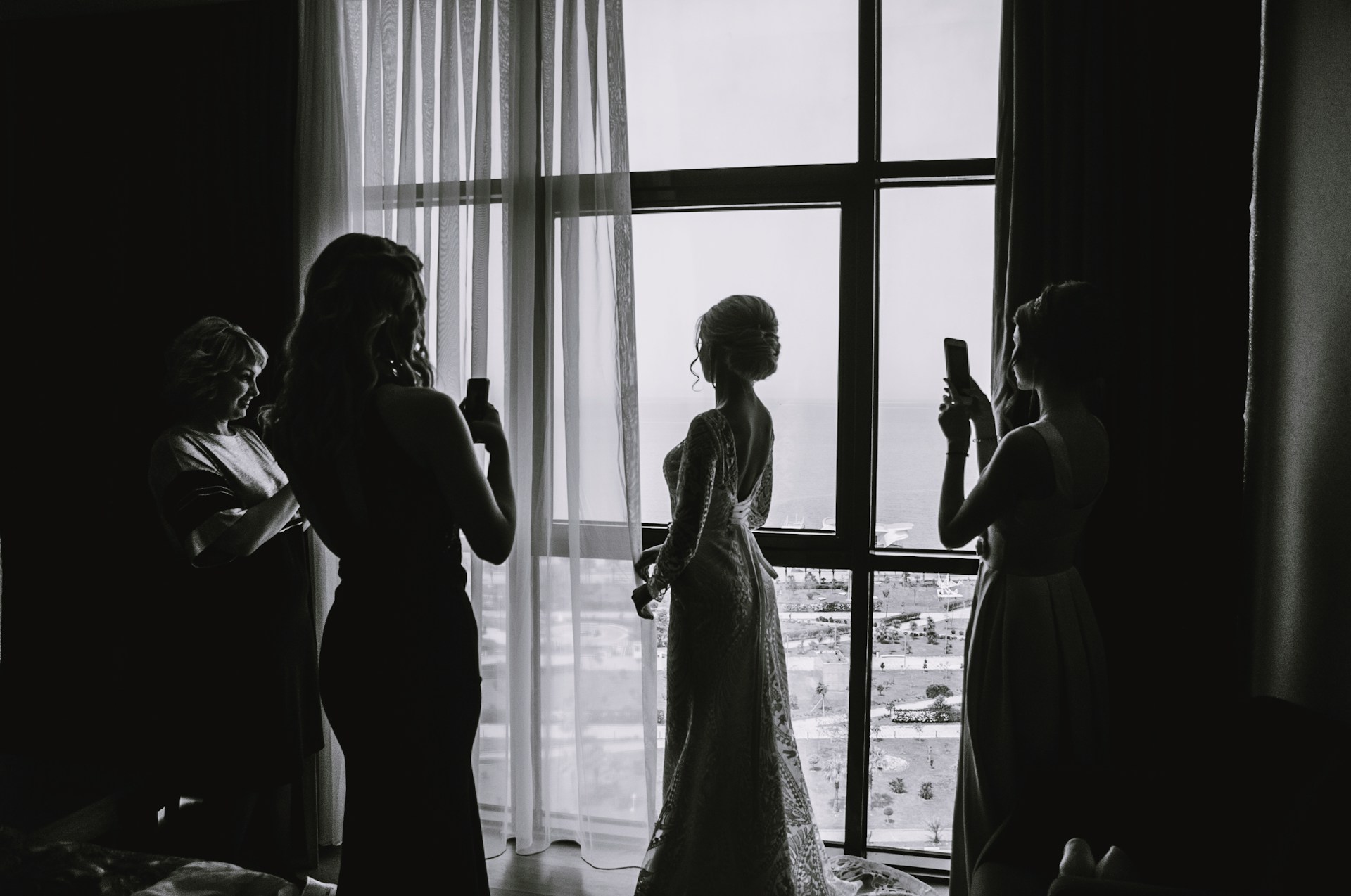Frauen, die Fotos von einer Braut in ihrer Suite machen | Quelle: Unsplash