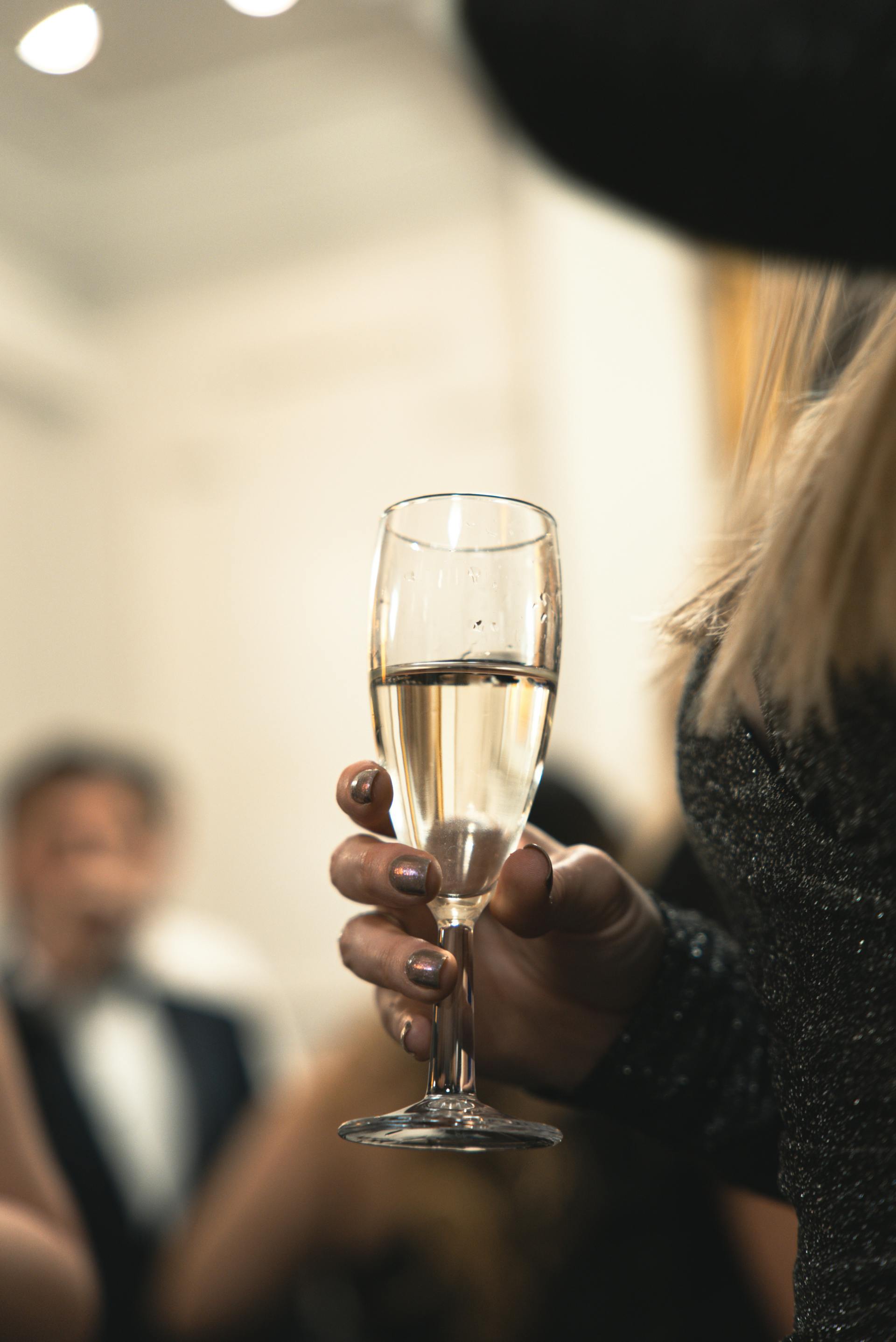 Eine Frau hält ein Glas Champagner bei einer Veranstaltung | Quelle: Pexels