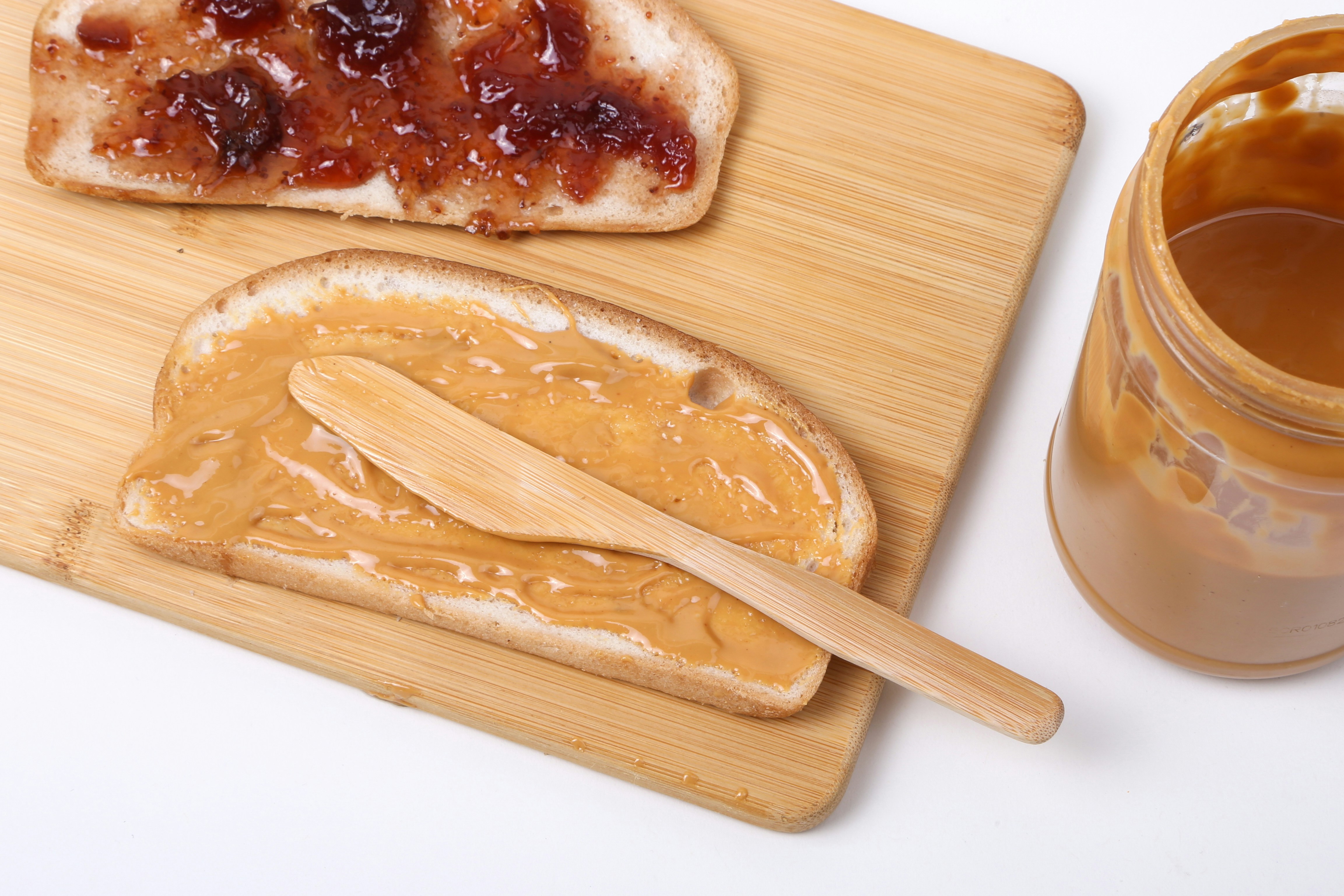 Erdnussbutter und Marmelade auf Brotscheiben | Quelle: Unsplash